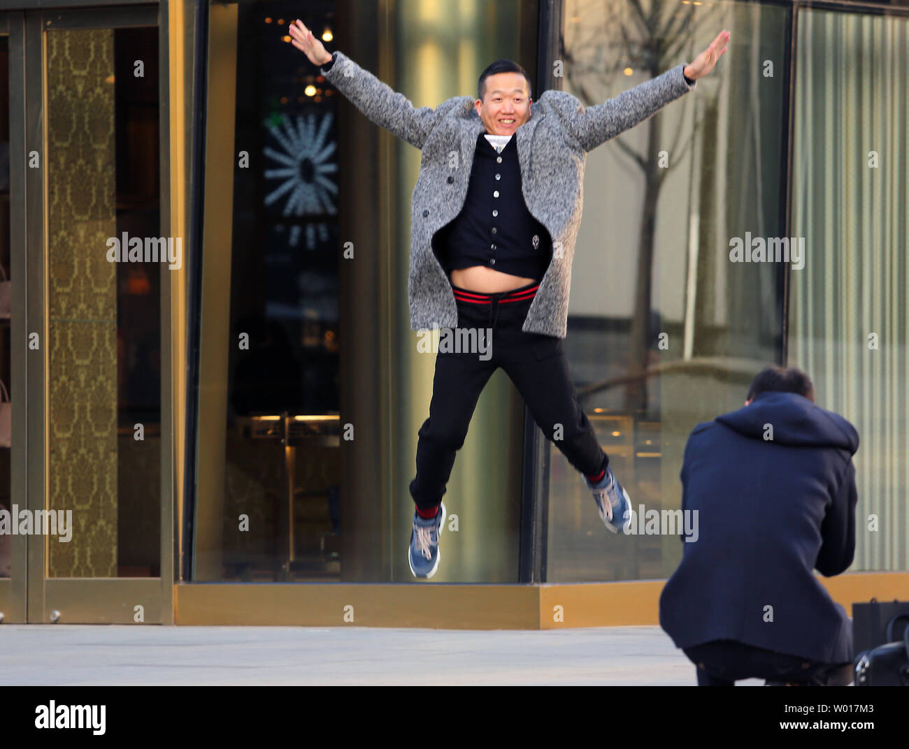 Ein chinesischer Mann springt in der Luft für ein Foto beim Einkaufen an einem upscale Fashion Mall in Peking am 23. März 2015. Für ein kommunistisches Land, es ist bemerkenswert, dass China hat eine Million Millionäre. China zählt jetzt nur nach den Vereinigten Staaten die Zahl der Superreichen hat es, trotz, dass Chinas durchschnittliche Einkommen ist das Gleiche wie in Peru. Foto von Stephen Rasierer/UPI Stockfoto