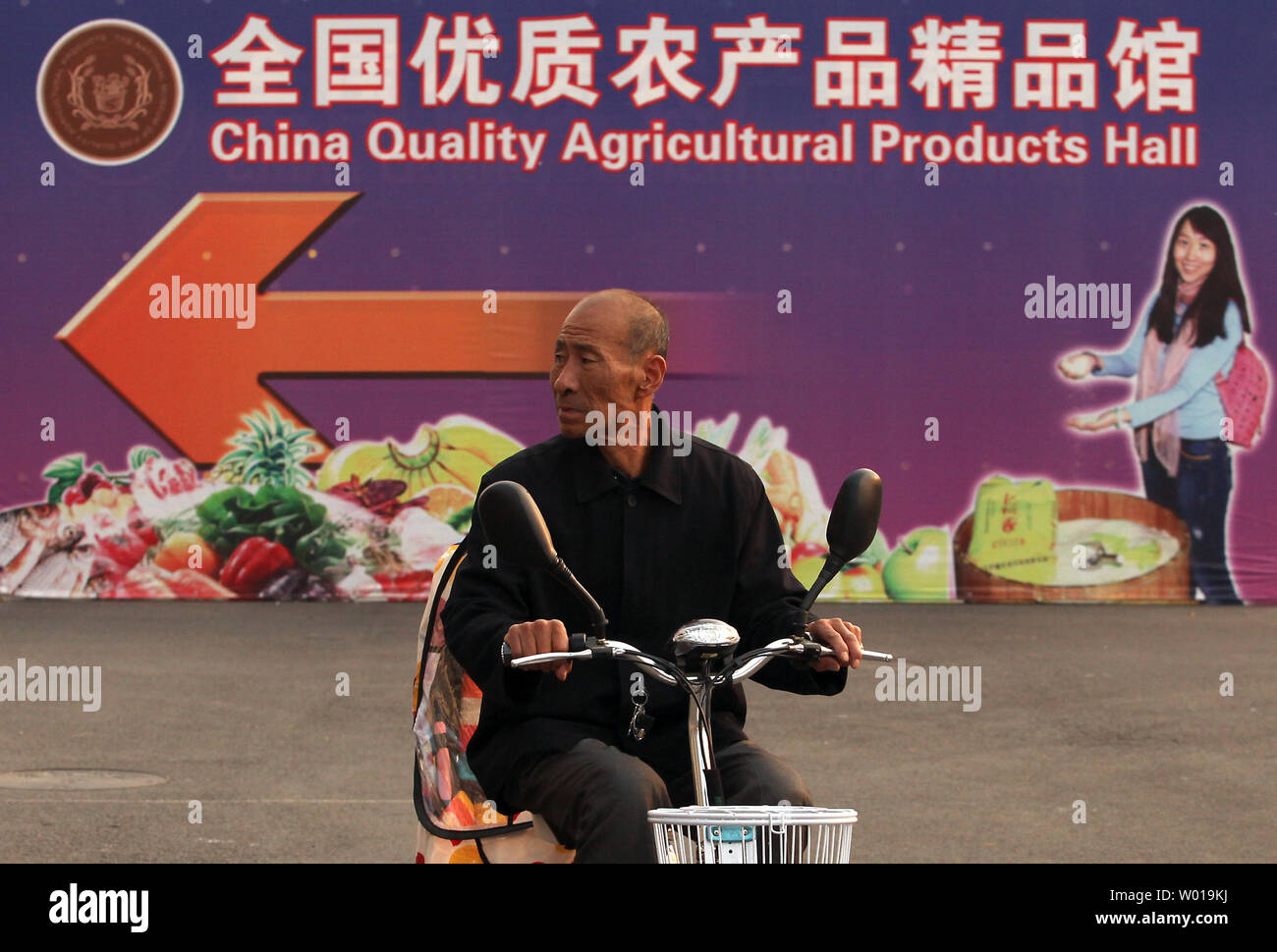 Ein chinesischer Mann sich eine Werbung für eine landwirtschaftliche Messe in Peking am 25. November 2015. Es gibt eine zunehmende Zahl von kleinen, boutique Farmen und organischen Bauernhöfen rund um die Hauptstadt Chinas, die chinesische Nachfrage gesünder landwirtschaftliche Produkte. Foto von Stephen Rasierer/UPI Stockfoto