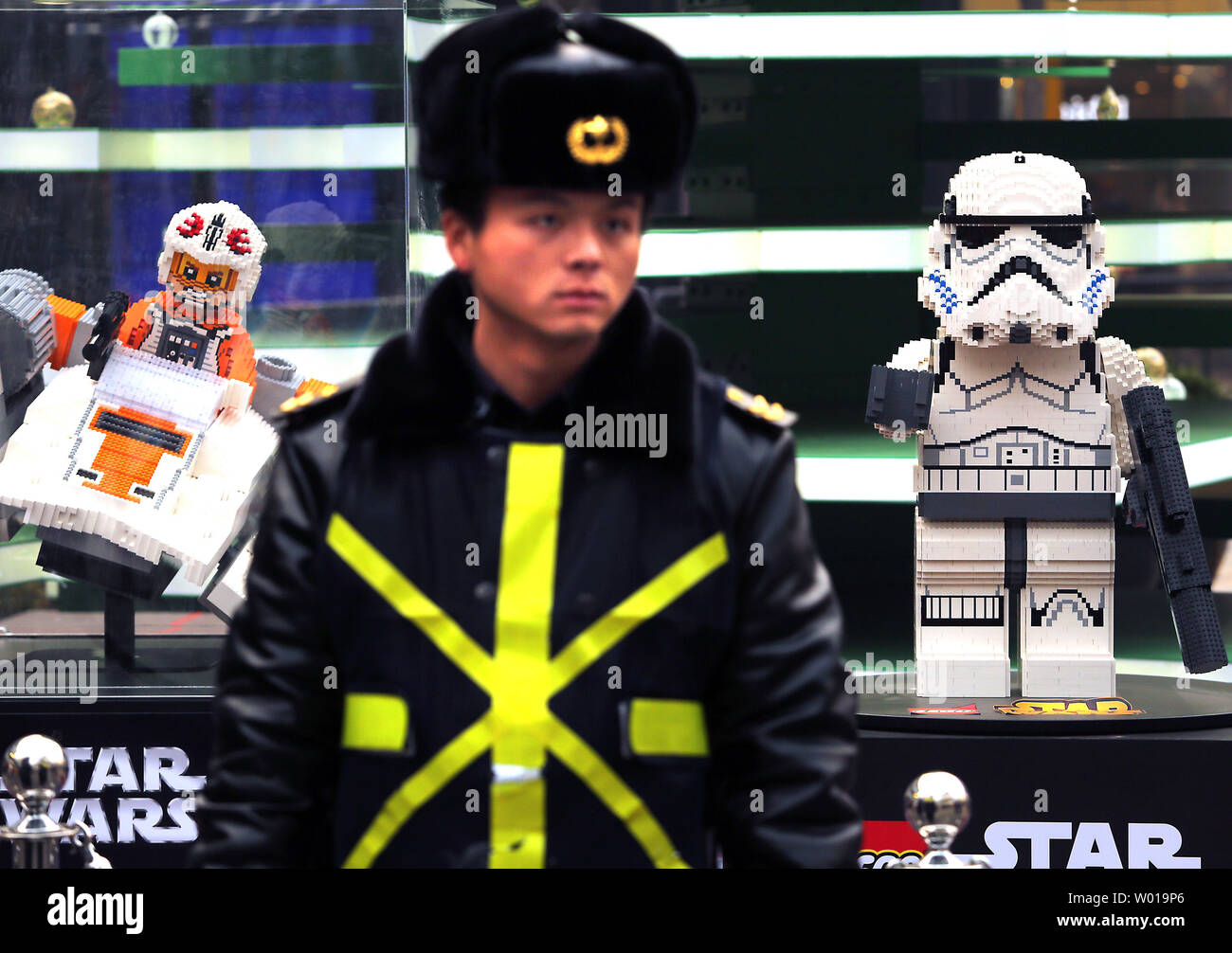 Ein chinesischer Sicherheitsmann steht vor einem Star Wars Lego Anzeige an einer Shopping Mall der anstehenden Veröffentlichung des neuen Star Wars Film in Peking am 6. Dezember 2015 zu fördern. China hat sich zu einem der wichtigsten Märkte von Hollywood für die Freigabe der Blockbuster. Foto von Stephen Rasierer/UPI Stockfoto