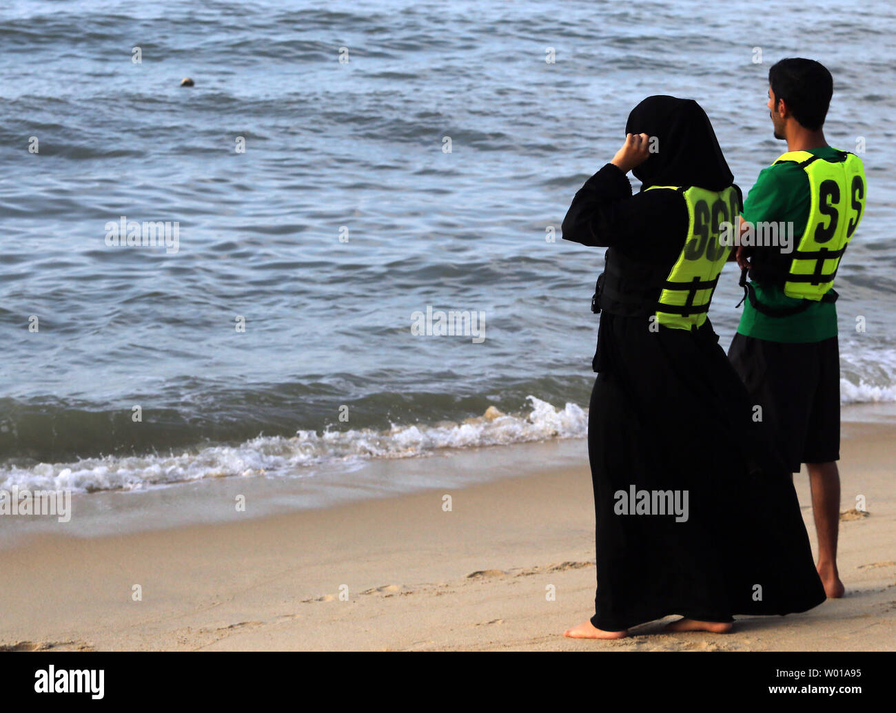 Eine muslimische Frau das Tragen einer Burka wartet mit einem Mann einen WaveRunner während einem Tag am Strand in Penang, Malaysia Fahrt am 21. Februar 2016. Malaysia ist ein überwiegend islamisches Land (sunnitischen) mit etwa 20 Millionen Anhänger, oder etwa 62 Prozent der Bevölkerung. Foto von Stephen Rasierer/UPI Stockfoto