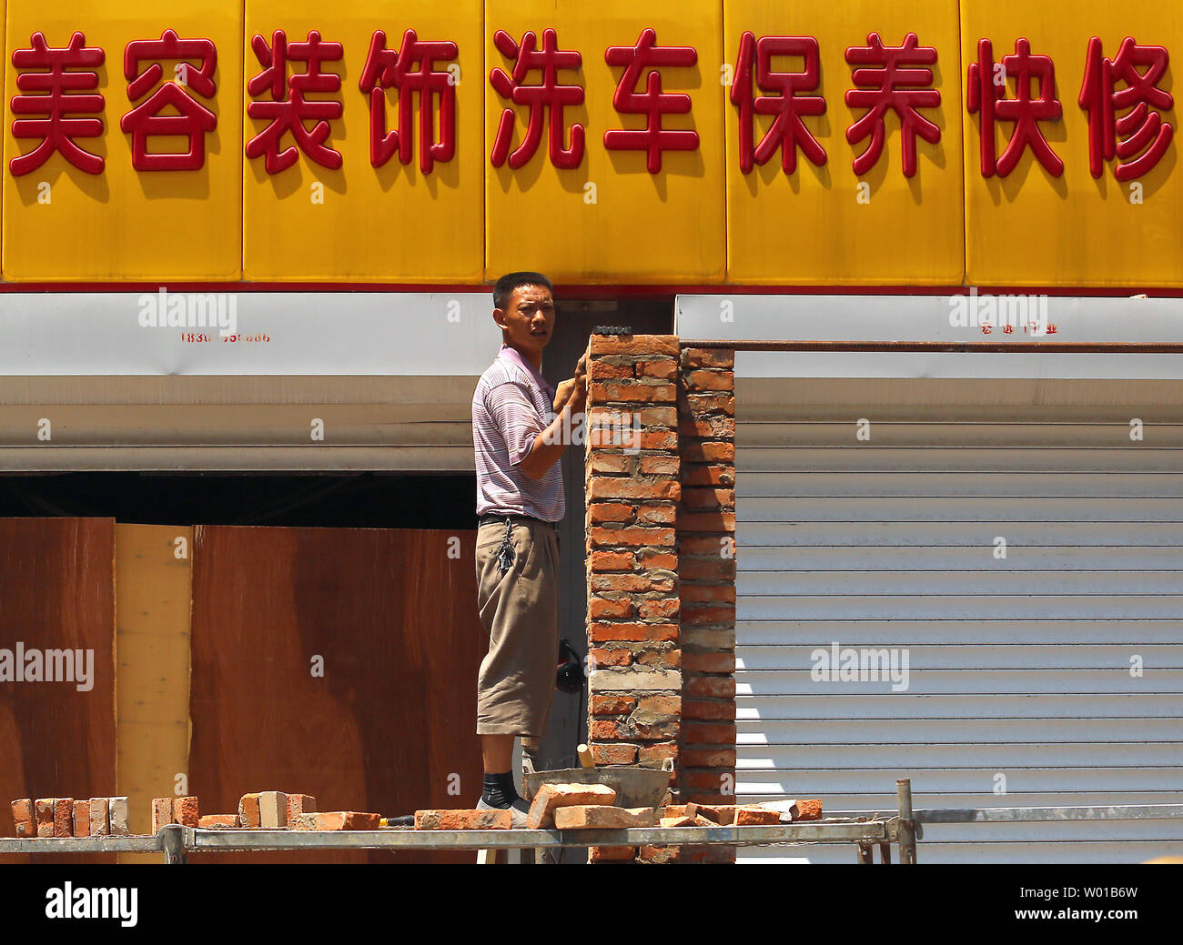 Ein chinesischer Arbeiter baut eine Mauer zwischen zwei Garagen im Zentrum von Peking am 27. Juni 2016. Turbulenzen unleashed von dem Britischen Abstimmung auf die Europäische Union (EU) verlassen erhöhte Ängste in Asien mit China, Japan und Südkorea alle über das finanzielle Risiko für ihre Volkswirtschaften alarmiert. Chinas Finanzminister sagte Fallout aus der vergangenen Woche Referendum" wird ein Schatten über der globalen Wirtschaft" werfen. Foto von Stephen Rasierer/UPI Stockfoto