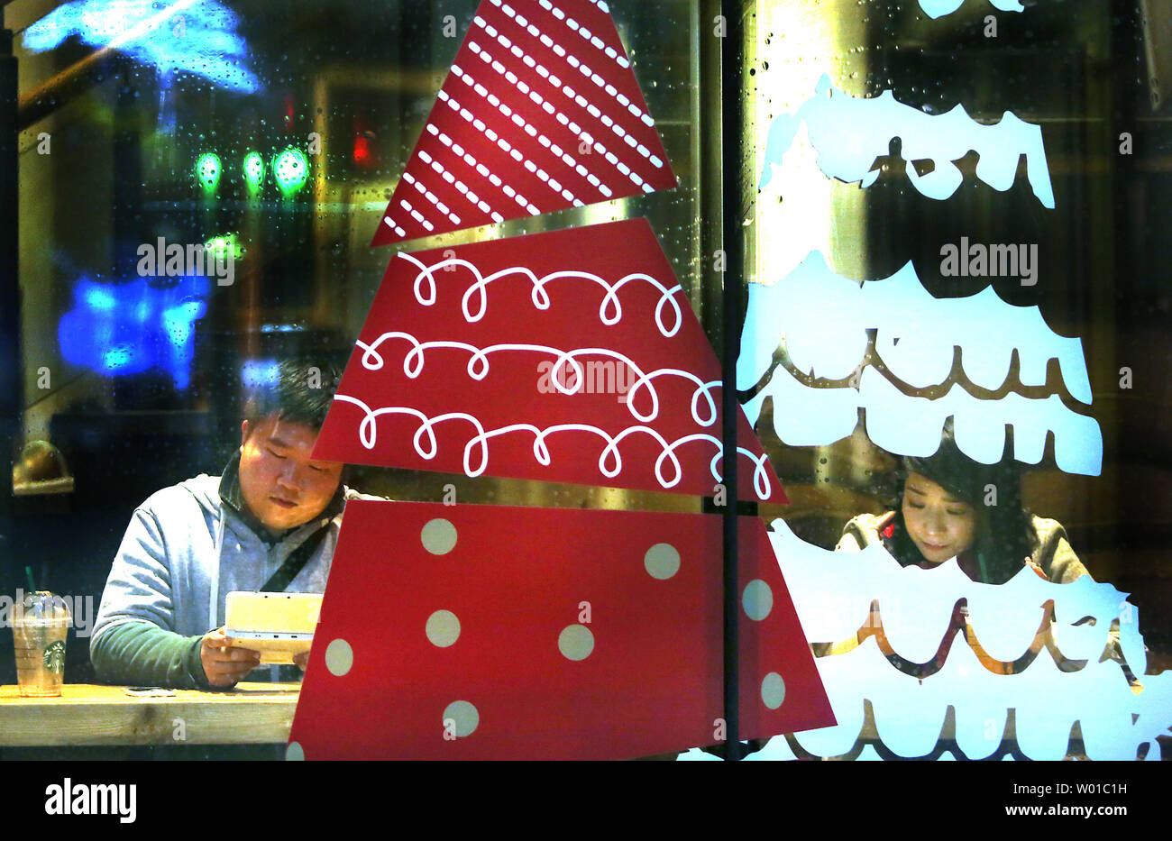 Chinesische besuchen Sie ein Weihnachten - gestaltet von Starbucks in der Innenstadt von Peking am 8. Dezember 2016. Starbucks sagte Mittwoch, den es erwartet von seinen schnell wachsenden China Business wird möglicherweise eines Tages eclipse seine US-Markt. Die Firma sagte auch, es plant, 12.000 zusätzliche Stores weltweit in den nächsten fünf Jahren zu öffnen. Foto von Stephen Rasierer/UPI Stockfoto