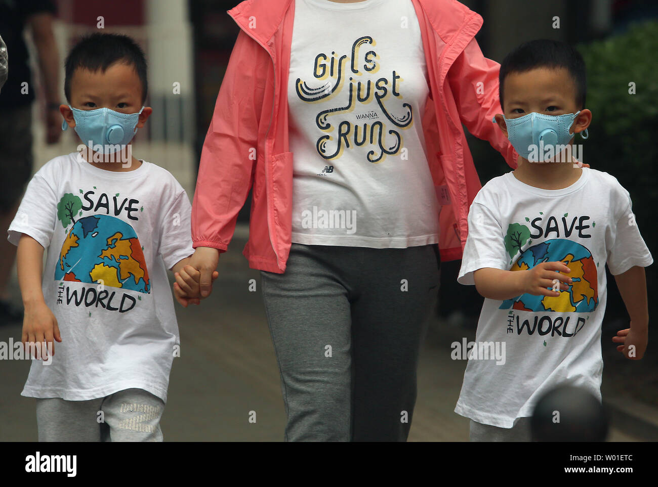 Eine Mutter und ihre Zwillinge tragen Gesichtsmasken gegen einen stark verschmutzten Tag in Peking am 12. Mai 2018 zu schützen. Chinas Luftverschmutzung führt 1,6 Millionen vorzeitige Todesfälle pro Jahr, nach Ansicht der Forscher am Institut für Arbeitsmedizin. Foto von Stephen Rasierer/UPI Stockfoto
