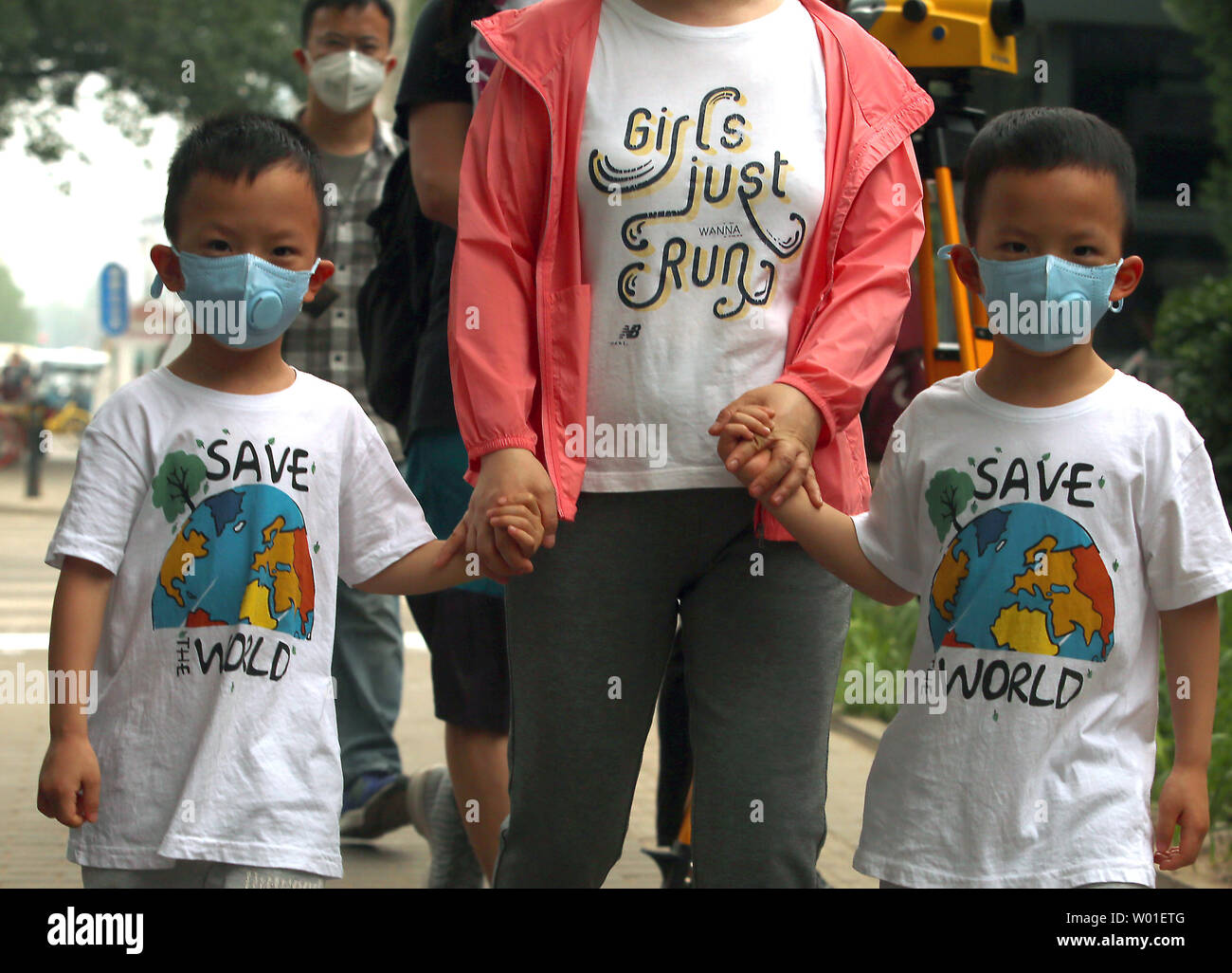 Eine Mutter und ihre Zwillinge tragen Gesichtsmasken gegen einen stark verschmutzten Tag in Peking am 12. Mai 2018 zu schützen. Chinas Luftverschmutzung führt 1,6 Millionen vorzeitige Todesfälle pro Jahr, nach Ansicht der Forscher am Institut für Arbeitsmedizin. Foto von Stephen Rasierer/UPI Stockfoto