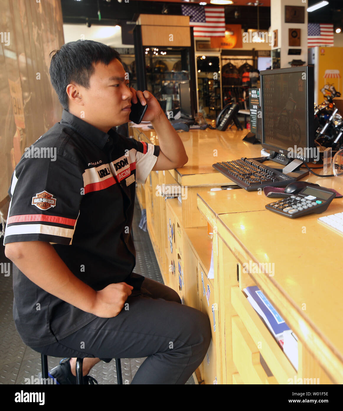 Eine chinesische Verkäufer Antworten das Telefon an einer Harley-Davidson Showroom in Peking am 27. Juni 2018. China, wie die Europäische Union (EU), hat mitgeteilt, dass sie die USA mit Tarifen am schlagen US-Präsident Donald Trump, wo es wehtut - speziell Harley-Davidson, Kentucky Bourbon und Sojabohnen ausgerichtet. Foto von Stephen Rasierer/UPI Stockfoto