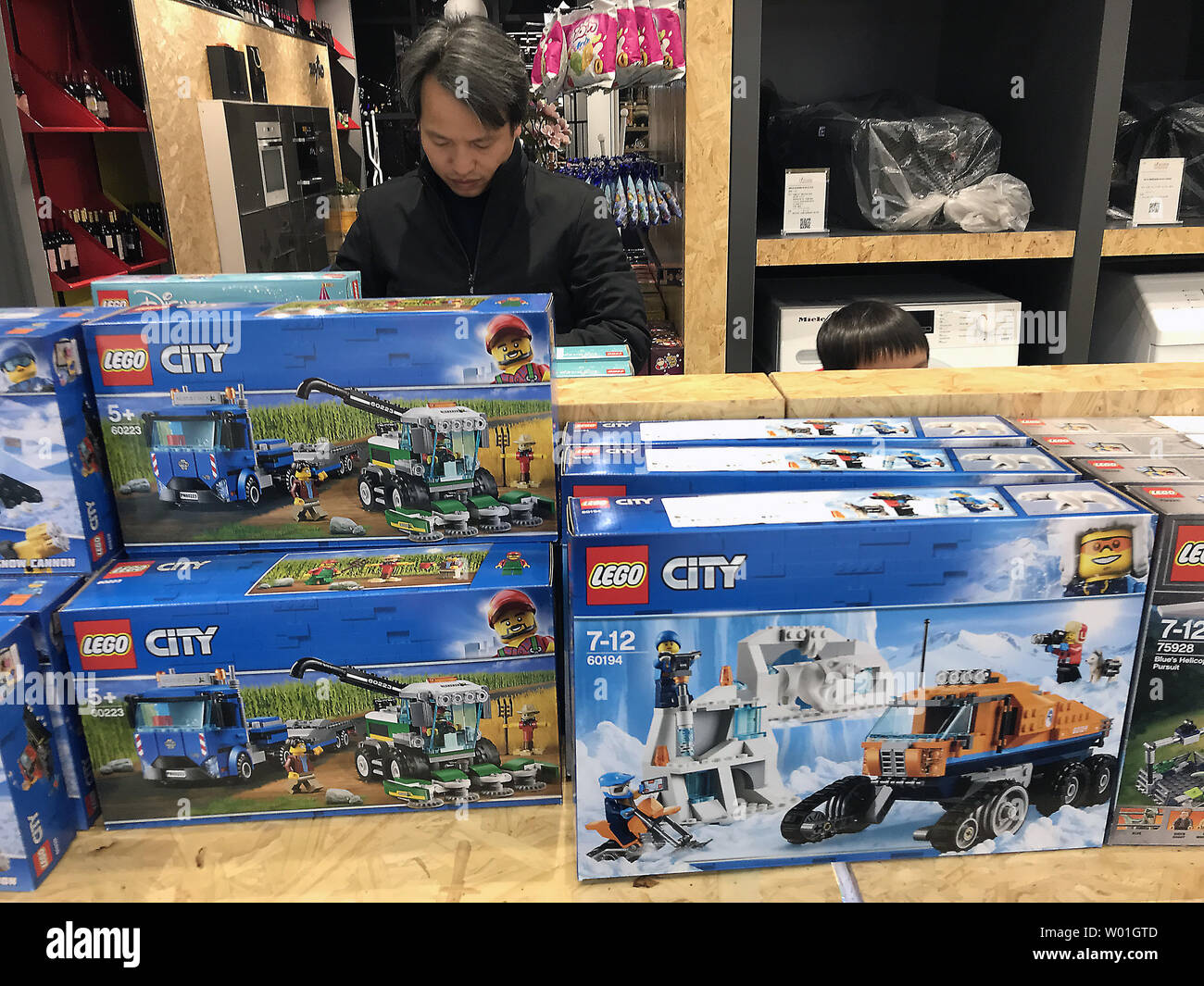 Chinesische Männer shop für importierte Lego Spielzeug Sets auf ein neu eröffnetes, internationale Shopping Mall in Peking am 18. Februar 2019. Trotz China" eine Verlangsamung der Wirtschaft und die ÜBERSCHATTUNG Handelskrieg mit den USA, China's neue Mittelschicht ist noch Einschalten die Eröffnung neuer internationaler Geschäfte mit der Kaufkraft der Verbraucher Wachstum im Markt zu erhalten. Foto von Stephen Rasierer/UPI Stockfoto