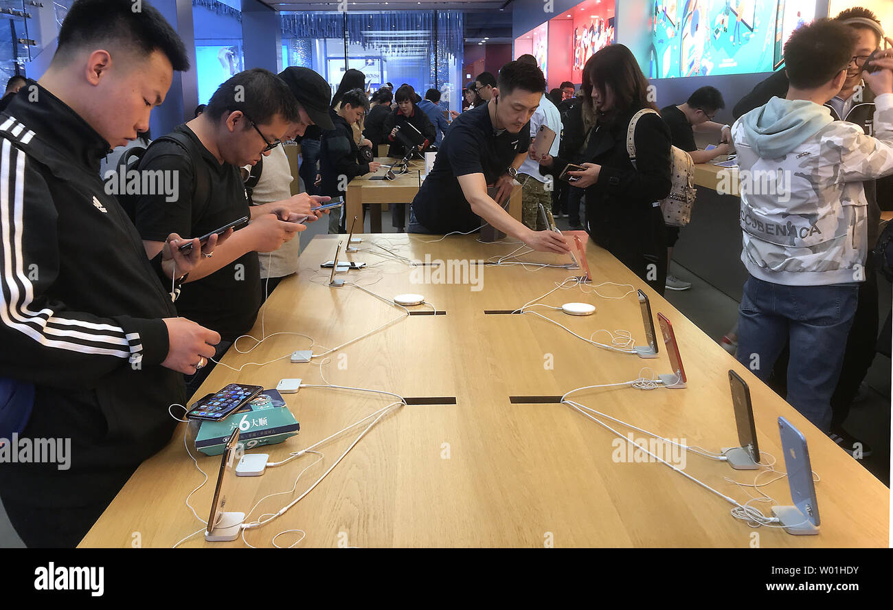 Chinesische überprüfen Sie die neuesten iPhones in Apple's Flagship Stores in Peking am 7. April 2019. Apple hat die Preise für einige seiner wichtigsten Produkte auf der offiziellen chinesischen Online Store um fast 6 Prozent, eine direkte Antwort auf eine steuerliche Veränderungen in China, die den Wert abgesenkt - Mehrwertsteuer für Luxus Hersteller wie Apple, nach Caixin. Foto von Stephen Rasierer/UPI.. Stockfoto