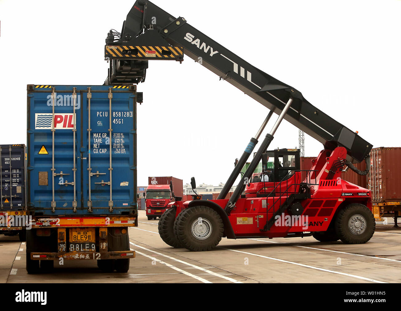 Container sind auf die wartenden Lkw Yiwu Railway Cargo Station in Wuhan, Provinz Zhejiang, am 13. April 2019 geladen. Die Yiwu - London Eisenbahnlinie ist die längste Eisenbahn freight Route in der Welt, zwischen China und Europa als Handel erhöht sich zwischen den beiden globalen Wirtschaftsmächte. Foto von Stephen Rasierer/UPI Stockfoto