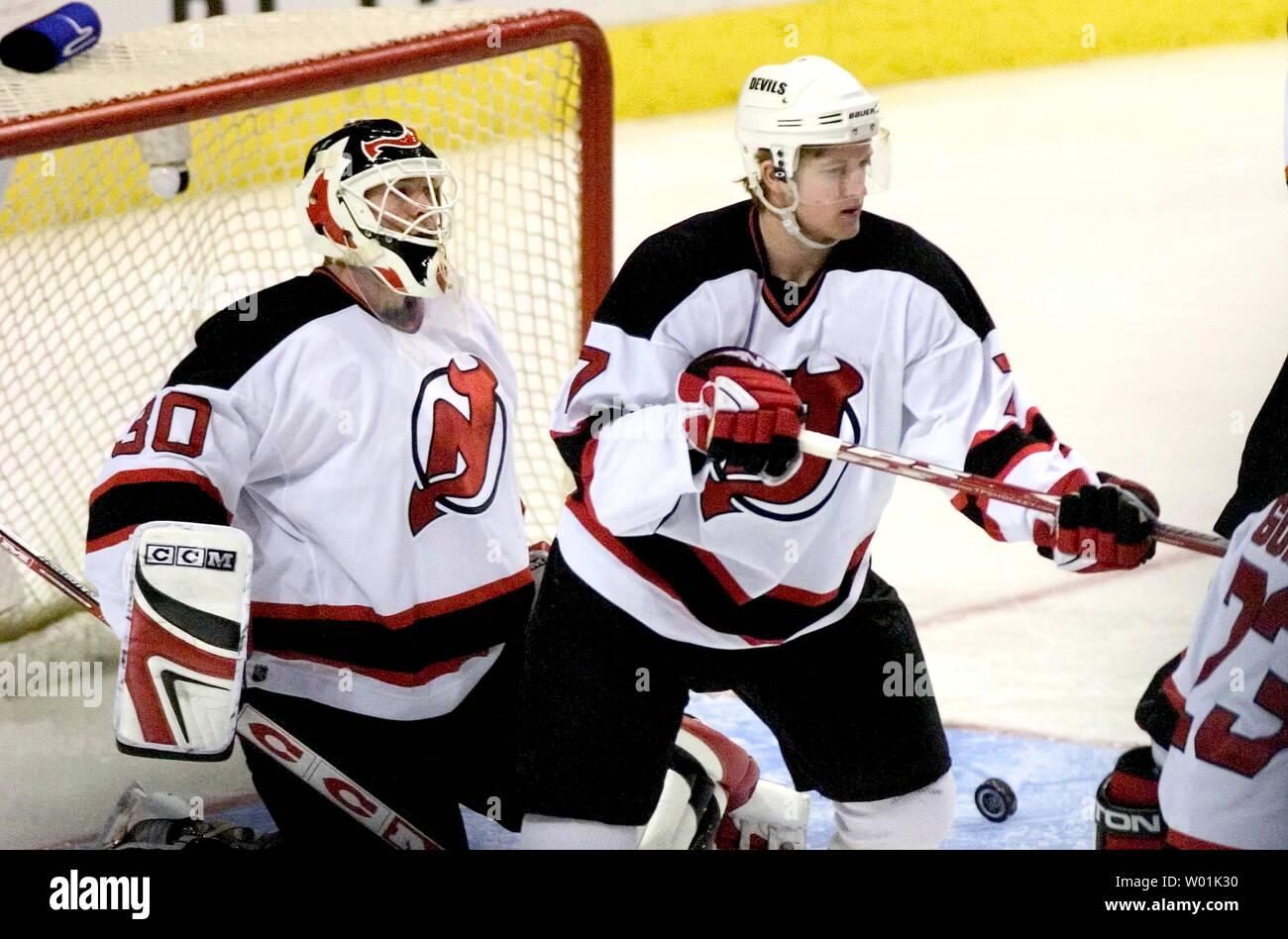 Die Devils' Torwart Martin Brodeur (30) und Teamkollege Paul Martin (7) aufgeben, das erste Ziel des Spiels auf den Flyer "Simon Gagne als Philadelphia hosts New Jersey in einem Nachmittag Spiel im Wachovia Center in Philadelphia, am 13. März 2004. (JON ADAMS/UPI) Stockfoto
