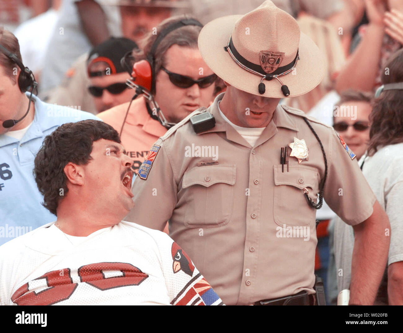 PHO 2000101511 - 15. Oktober 2000 - Tempe, Arizona, USA: eine irateArizona Kardinäle Lüfter schreit ein Arizona State Trooper, da er aus dem Stadion geführt nach lächerlichmachen der Kardinäle" spielen Sie gegen die Philadelphia Eagles im Sun Devil Stadium in Tempe, Arizona, 15. Oktober 2000. Die Adler schlugen die Kardinäle 33-14. Der Verlust sank die Kardinäle zu 2 - 4. Die Adler verbesserte sich auf 4-3. cc/jk/Jack Kurtz UPI Stockfoto