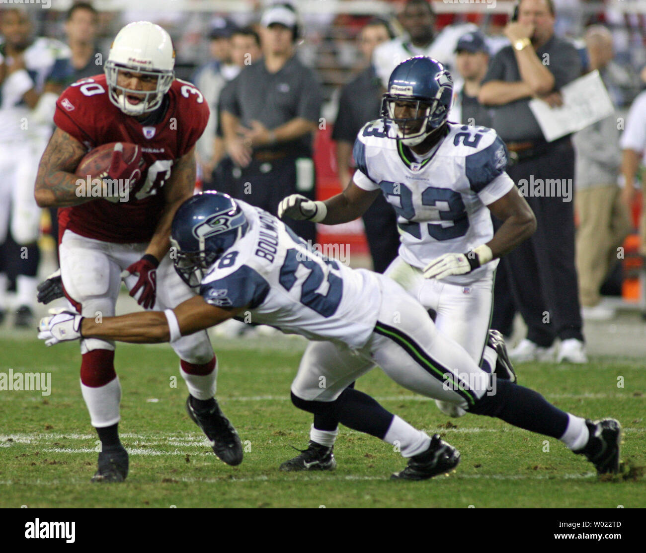 Arizona Cardinals Verteidiger Obafemi Ayanbadejo (30) Köpfe unten Feld als Seattle Seahawks Sicherheit Michael Boulware (28) versucht, die Bekämpfung als cornerback Marcus Trufant (23) kommt während der ersten Hälfte Aktion an der Universität von Phoenix Stadium in Glendale, Arizona am 10. Dezember 2006 zu helfen. (UPI Foto/Kunst Foxall) Stockfoto