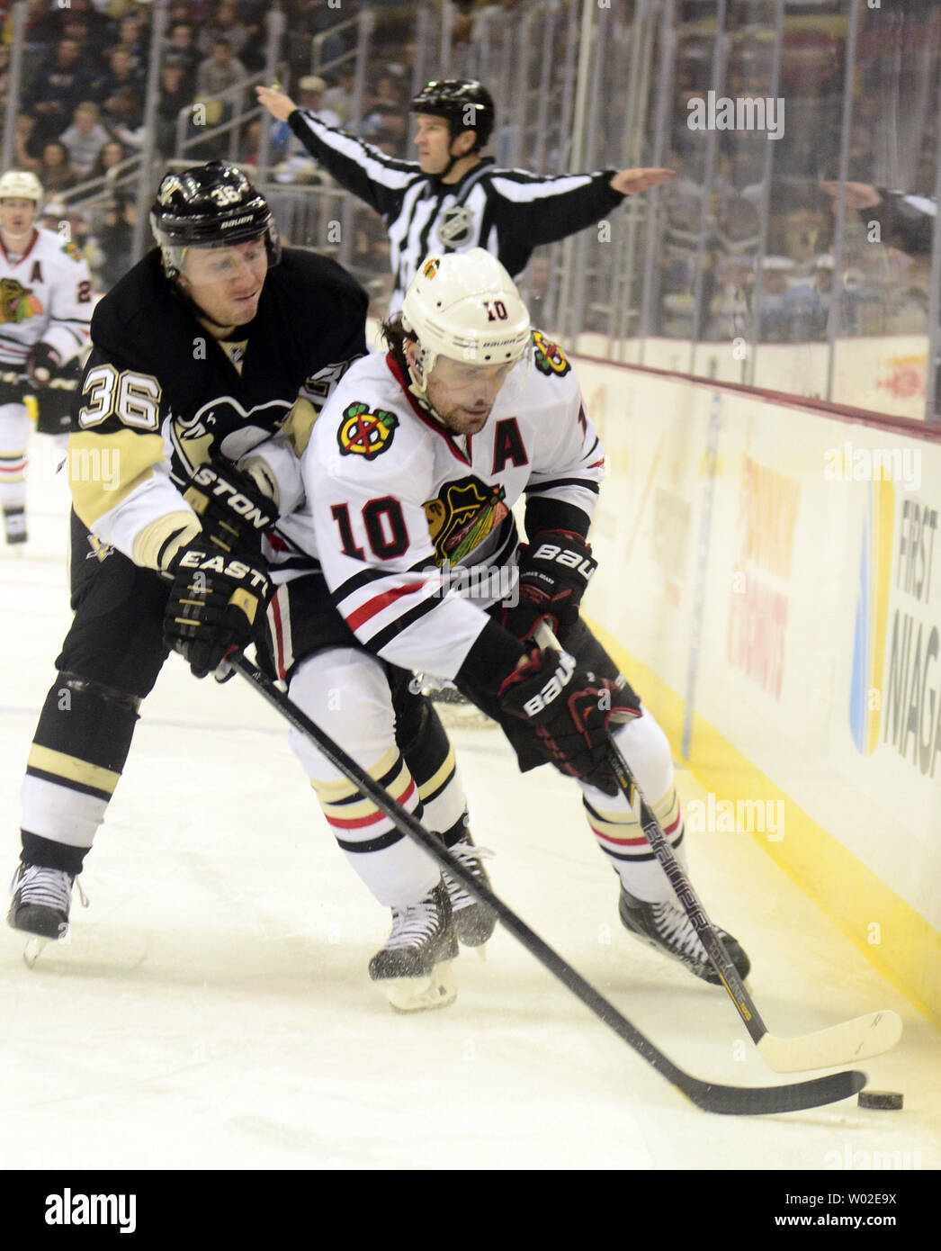 Chicago Blackhawks linken Flügel Patrick Sharp (10) spielt den Puck an den Brettern, als Pittsburgh Penguins linken Flügel Jussi Jokinen (36) erreicht in der ersten Periode am Consol Energy Center in Pittsburgh am 30. März 2014. UPI/Archie Tischler Stockfoto