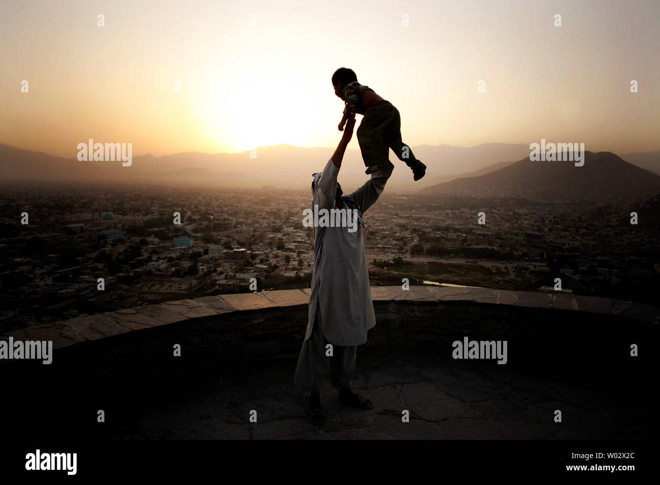 Ein Mann spielt mit seinen Jungen bei Sonnenuntergang Blick auf Kabul City ist im Hintergrund in Afghanistan am 29. August 2009 gesehen. UPI/Mohammad Kheirkhah Stockfoto