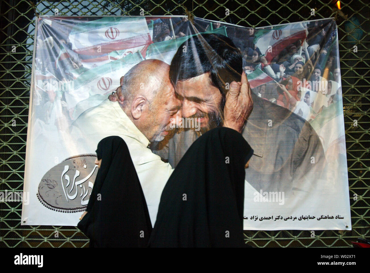 Zwei iranische Frauen pass ein Banner mit Irans Präsident Mahmud Ahmadinedschad auf einer Kundgebung in Teheran, Iran am 31. Mai 2009. Die iranischen Präsidentschaftswahlen am 12. Juni. UPI/Mohammad Kheirkhah Stockfoto