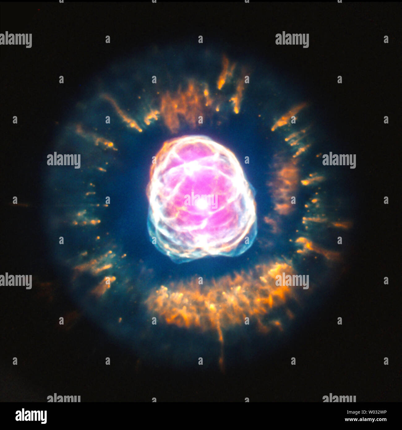 Sterne können bemerkenswert fotogen am Ende ihres Lebens geworden, wie NGC 2392, der "Eskimo nebula', das liegt etwa 4200 Lichtjahre von der Erde entfernt. Planetarische Nebel wie NGC 2392, Form, wenn ein Star alle der Wasserstoff im Kern. Wenn dies geschieht, wird der Stern beginnt zu kühlen und zu erweitern und die äußeren Schichten der Sterne sind weg von einer dicken 50.000 Kilometer pro Stunde Wind getragen, und hinter einer heißen Kern mit einer Oberflächentemperatur von etwa 50.000 Grad Celsius. Die Strahlung von der heißen Sterne und die Interaktion seiner schnellen Wind mit dem langsameren Wind schafft die Hülle eines planetarischen Stockfoto