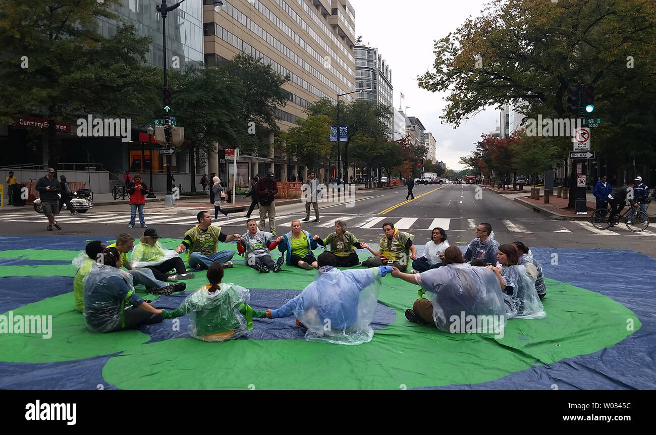 Die Demonstranten fordern höhere Löhne für Walmart Arbeiter sitzen in der Mitte der K Street in der Innenstadt von Washington, DC am 16. Oktober 2014. Der Protest außerhalb der Walton Family Foundation an der K Street und 18. Straße blockiert den Schnittpunkt für mehr als eine Stunde führen zu massiven Staus ein paar Blöcke vom Weißen Haus entfernt. 16 Demonstranten wurden festgenommen. UPI/Pat Benic Stockfoto