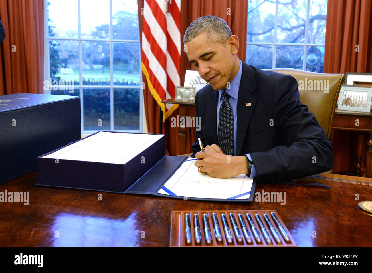 Us-Präsident Barack Obama unterzeichnet ein $ 1,15 Billionen ende Steuerpaket (Links) im Oval Office des Weißen Hauses in Washington, DC am 18. Dezember 2015. Die große Rechnung wurde vom Kongress früh am Tag genehmigt und enthält Steuererleichterungen für Unternehmen und Bürger mit niedrigem Einkommen. Foto von Pat Benic/UPI Stockfoto