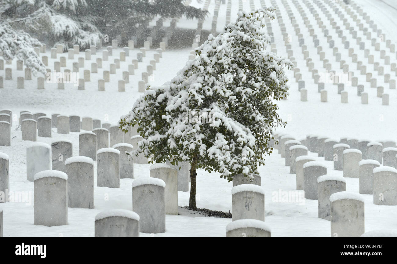 Schwere Schnee decken Gräber und Bäume auf dem Gelände des Arlington National Friedhof, 5. März 2015 in Arlington, Virginia. Mit bis zu 20 Zentimeter von der Sturm, die Bundesregierung und die Schulen sind geschlossen, wie Straßen und Autobahnen beginnen verräterische zu erhalten. Foto von Mike Theiler/UPI Stockfoto