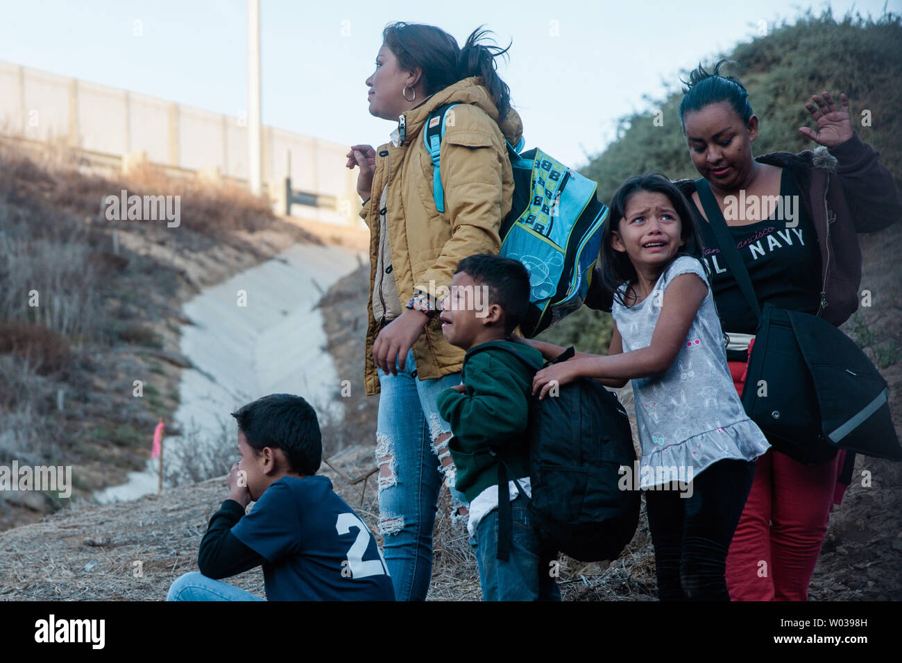 Eine Familie blickt zurück auf den Grenzzaun, teilt den Vereinigten Staaten und Mexiko in der Nähe von Las Playas de Tijuana, nach den Zaun springen und Eingabe der USA in San Ysidro, Kalifornien, am 2. Dezember 2018. Foto von Ariana Drehsler/UPI Stockfoto