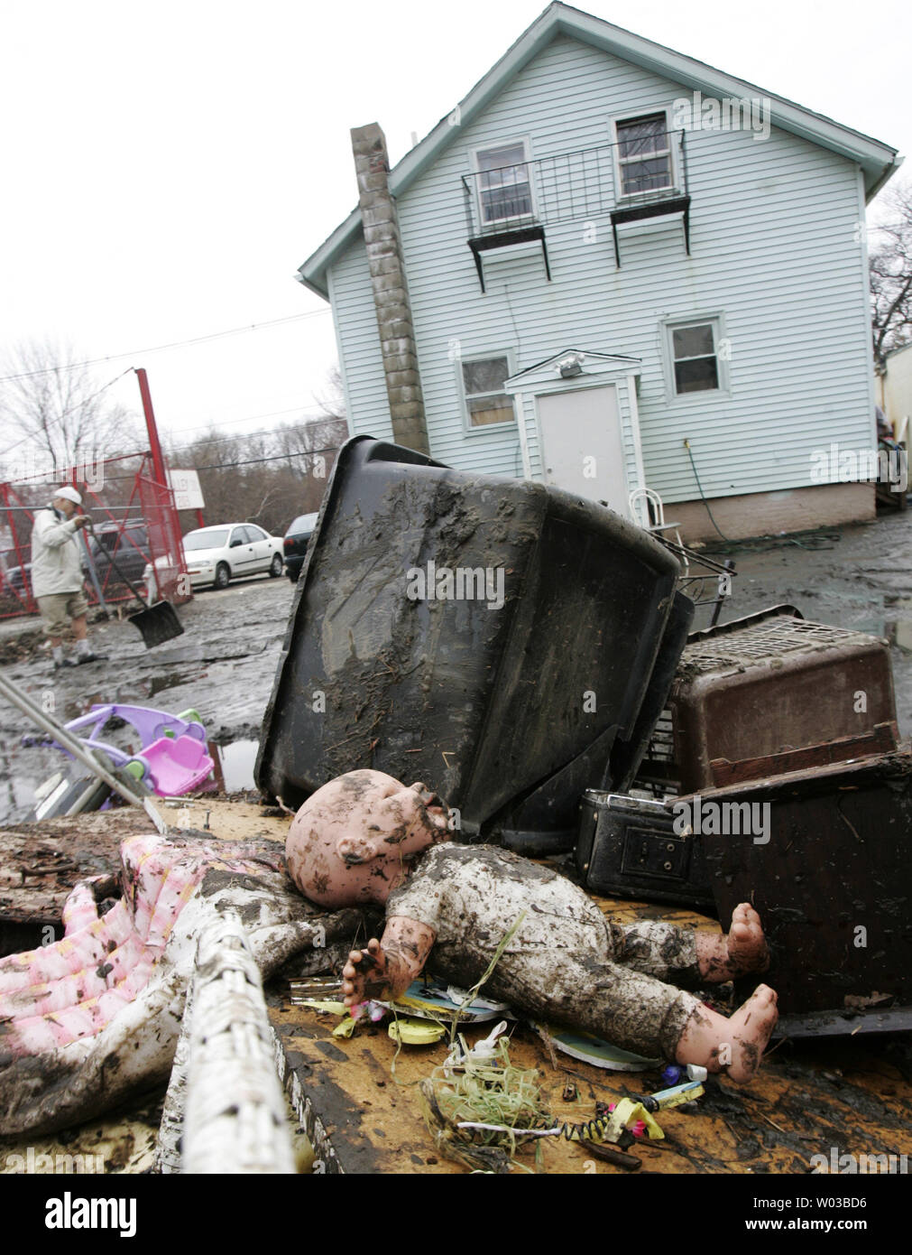 Puppe eines Kindes ruht auf einem Haufen von Haushaltsgegenständen, die während der Überschwemmung des Morales' Haus auf Tal Straße in der Vorsehung zerstört wurden, Rhode Island am 1. April 2010. Nicholas Morales (L) setzt sich im Hinterhof des Hauses zu Reinigen nach dem nahe gelegenen Fluss Woonasquatucket lief über die Banken nach dem Zustand Rekordniederschlags früh in der Woche empfangen. UPI/Matthew Healey Stockfoto