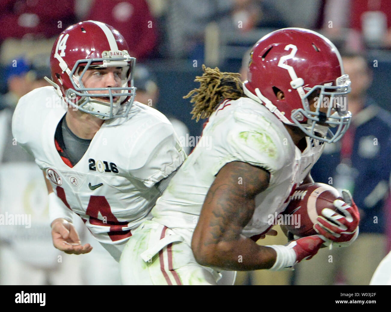 Alabama Crimson Tide Quarterback Jake Coker (L) Hände weg zu laufen zurück Derrick Henry als Henry Köpfe in für seinen zweiten Touchdown des Spiels gegen die Clemson Tiger im zweiten Quartal des College Football Endspiel nationale Meisterschaft 2016 an der Universität von Phoenix Stadium in Glendale, Arizona am 11. Januar 2016. Foto von Kunst Foxall/UPI Stockfoto