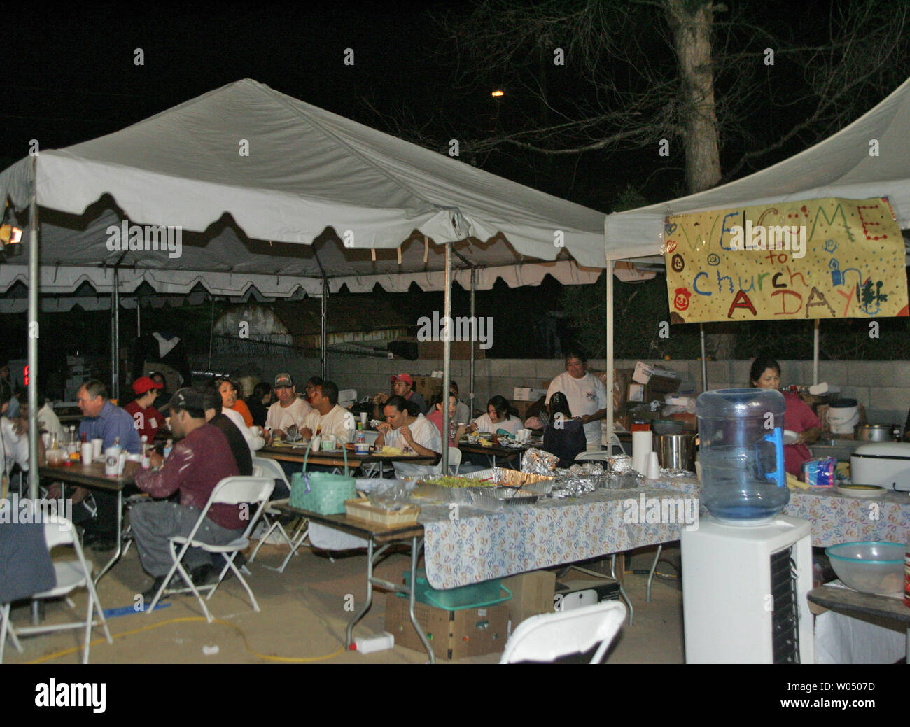 Freiwillige sind gefüttert, da sie durch die nachtarbeit Kaliforniens erste 'Kirche in einem Tag" in Barrio Logan, San Diego, CA, 19. November 2005 zu bauen. Die Vereinigte Pfingstgemeinde, auf einer Website, die noch eine Deponie am Freitag wurde gebaut, ist geplant für Sonntag nachmittag Dienstleistungen abgeschlossen sein. (UPI Foto/Roger Williams). Stockfoto