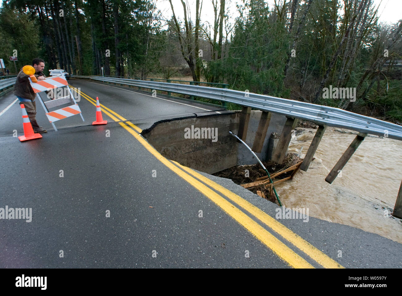 Kitsap County Arbeiter Brad Nelson Orte ein Warnschild in der Nähe einer Brücke heraus gewaschen, dass in Chico Creek in Bremerton, WA collasped., am 4. Dezember 2007. Brechen Niederschlag von 7,5 Zoll Datensatz beworfen Kitsap County am Sonntag und Montag, Schließen von Straßen, Brücken, Waschmaschine und Überflutungen Häuser und Geschäfte. (UPI Foto/Jim Bryant) Stockfoto