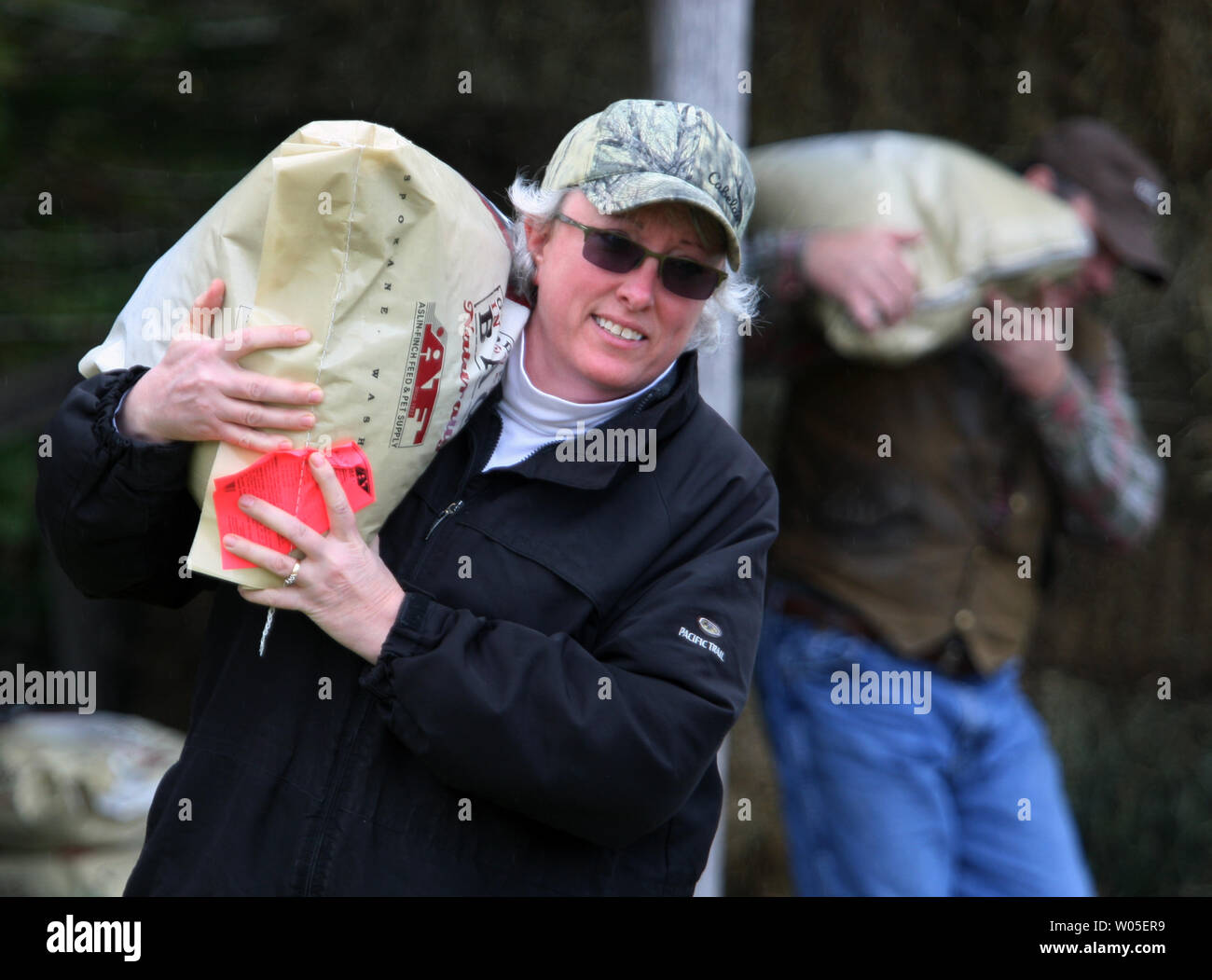 Roxanne, Front, und Dan Moore haul Bags von Futter für die geretteten Pferde und Ponys zum darrington Rodeo Gelände am 27. März in Darrington, Washington 2014. Sieben Pferde wurden gerettet, die von einem Bauernhof in der Zeit nach der Schlammlawine, die die Stadt von Oso begraben, etwa 12 Meilen westlich von Darrington. Über 200 Such- und Rettungskräfte noch nach Überlebenden oder Einrichtungen inmitten der sich verschlechternden Wetterbedingungen. Rund 25 Einrichtungen mit mehr als 90 fehlt in den tragischen Schlammlawine entdeckt worden zu suchen. UPI/Jim Bryant Stockfoto