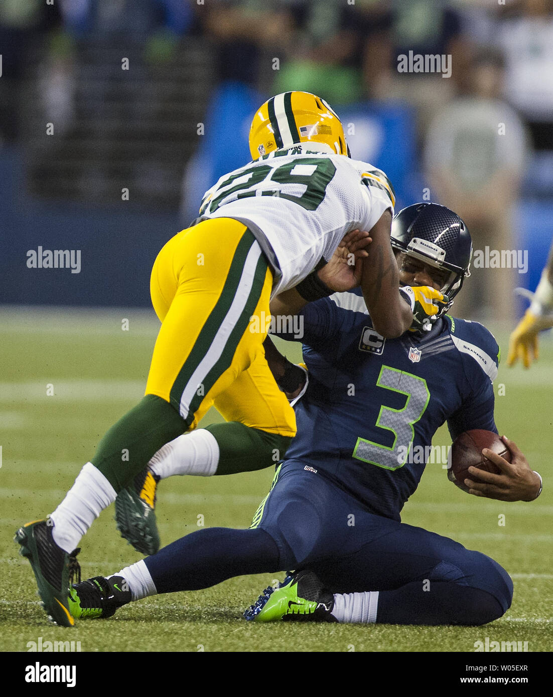 Seattle Seahawks Quarterback Russell Wilson (3) nach unten gezogen wird durch sein Gesicht Maske durch die Green Bay Packers cornerback Casey Hayward (29) Im vierten Quartal des NFL Start am CenturyLink Feld September 4, 2014 in Seattle. Casey war auf der Spiel markiert. Wilson führte 19 Pässe für 191 Yards, 29 Yards gehetzt wie die Seahawks schlagen die Verpacker 36-16. UPI/Jim Bryant Stockfoto