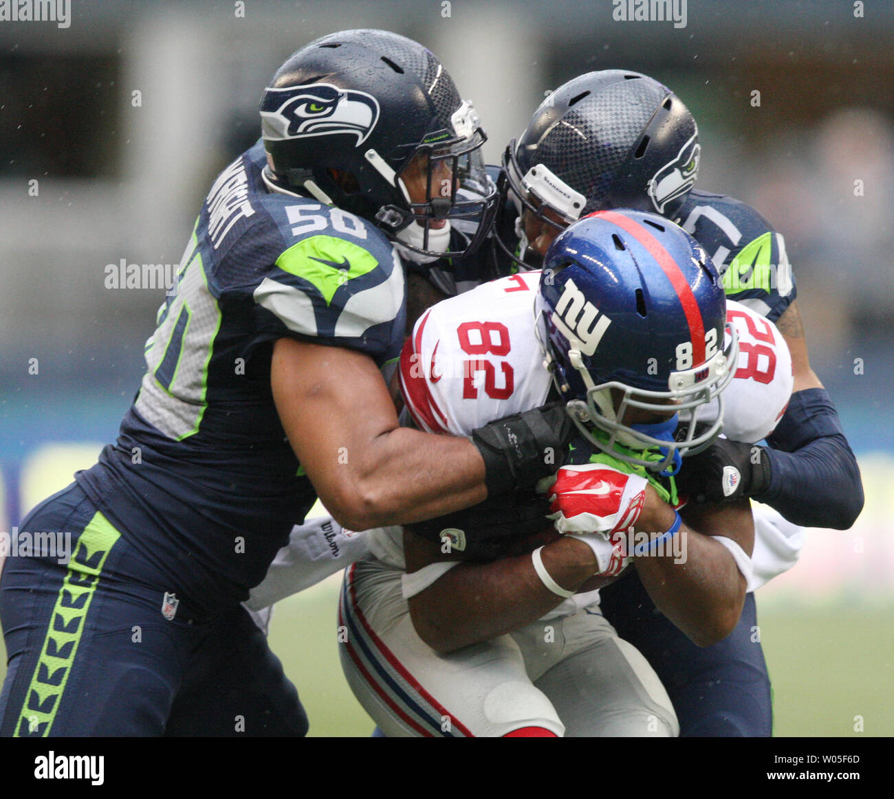 Seattle Seahawks linebacker K.J. Wright (50) und cornerback Tharold Simon (27) wickelt oben New York Giants wide receiver Rueben Randle (82) an: CenturyLink Feld in Seattle, Washington, am 9. November 2014. Die Seahawks schlagen die Riesen 38-17. UPI/Jim Bryant Stockfoto