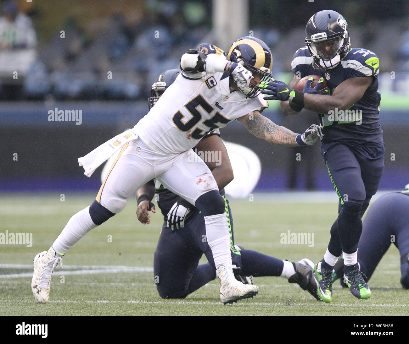 Seattle Seahawks zurück läuft, Christian Michael (32) eilt Vergangenheit St. Louis Rams Linebacker James Laurinaitis (55) an: CenturyLink Feld in Seattle, Washington am 27. Dezember 2015. Die Rams schlagen die Seahawks 23-17. Foto von Jim Bryant/UPI Stockfoto