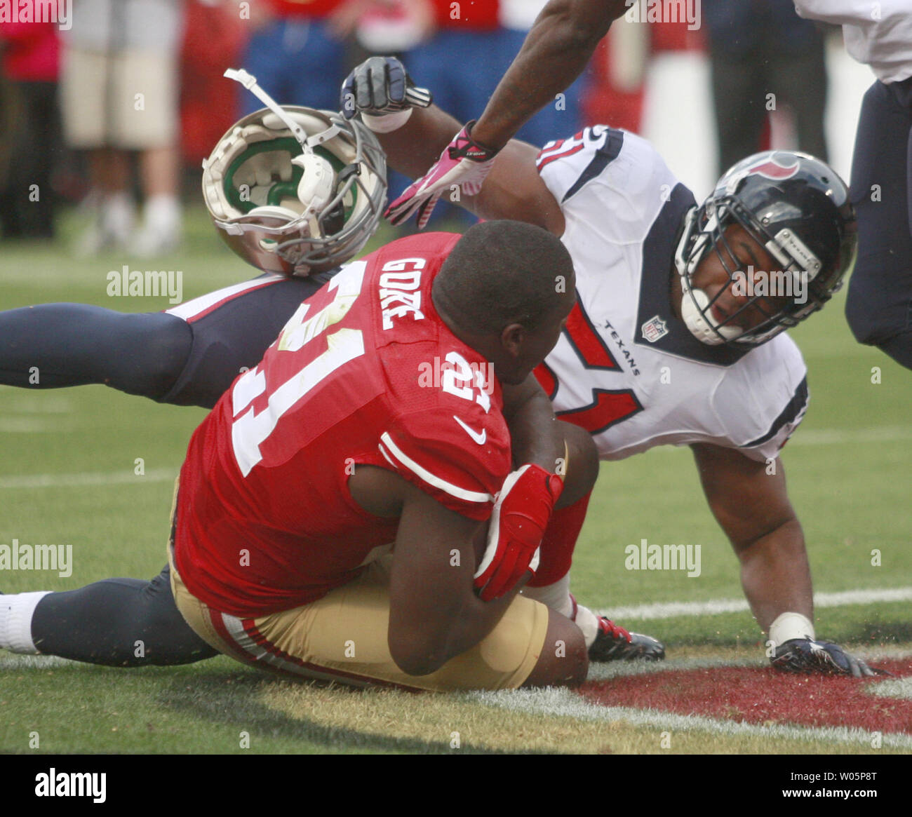 San Francisco 49ers RB Frank Gore (21) hat seinen Helm weg zerrissen durch Houston Texans Darryl Sharpton (51) beim Zählen ein 1 Yard TD im ersten Quartal bei Candlestick Park in San Francisco am 6. Oktober 2013. Die 49ers in den Texans 34-3 gerollt. UPI/Bruce Gordon Stockfoto