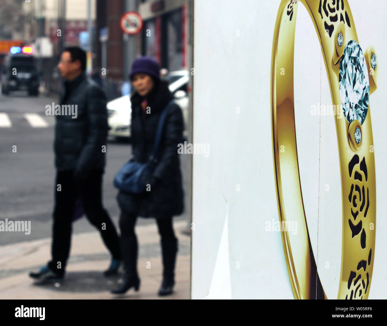 Chinesische vorbei einen neuen Schmuck Shop in Shanghai am 2. Februar 2015. Chinas Dienstleistungssektor wuchs am langsamsten Schritt in einem halben Jahr im Januar als Wachstum im Neugeschäft geschwächt, die Erwartungen, die die politischen Entscheidungsträger kann mehr stimulus Schritte eine schärfere Wachstumsverlangsamung in die zweitgrößte Volkswirtschaft der Welt abzuwenden. Foto von Stephen Rasierer/UPI Stockfoto