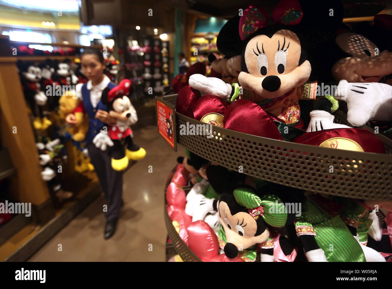 Eine chinesische Verkäuferin stocks Puppen Disney's berühmten Zeichen an einem Souvenirshop in Shanghai Disney Resort am 14. August 2017. Shanghai Disneyland ist der größte ausländische Investitionen und strebt in China rasant wachsenden Mittelschicht - ein Schlüssel für die Zukunft des Unternehmens, nach Disney. Foto von Stephen Rasierer/UPI Stockfoto