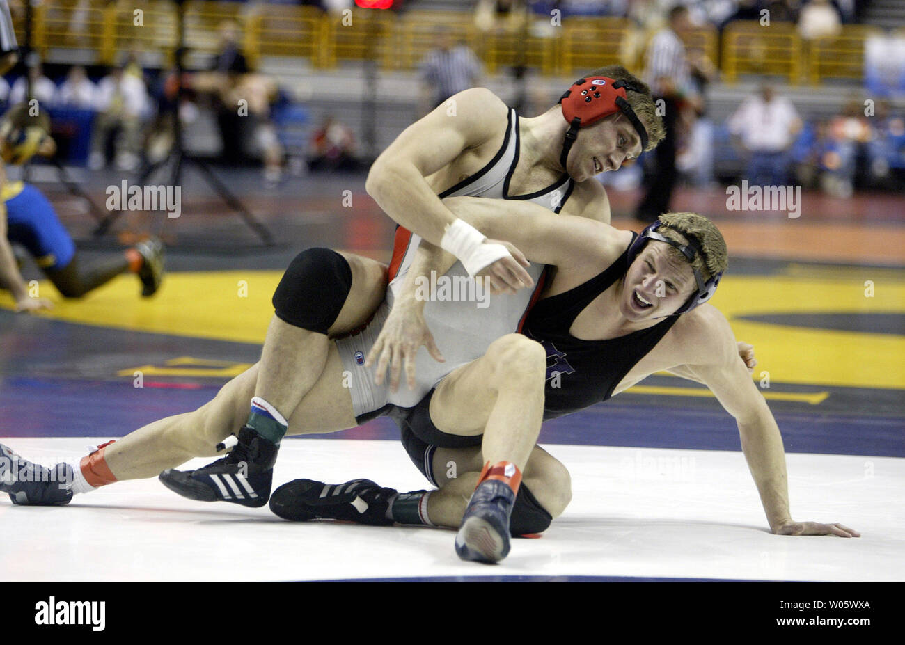 John Clark von Ohio State (oben) sperrt Hesston Johnson von Northern Iowa in Ihren 165 Pfund, Runde eins in der NCAA Division 1 Wrestling Meisterschaften am Savvis Center in St. Louis am 18. März 2004 entsprechen. Drei hundert und dreißig Stiftskirche Ringkämpfer aus dem ganzen Land stellen weg in Hunderten von Spielen zwischen heute und am 20. März. (UPI Foto/Rechnung Greenblatt) Stockfoto