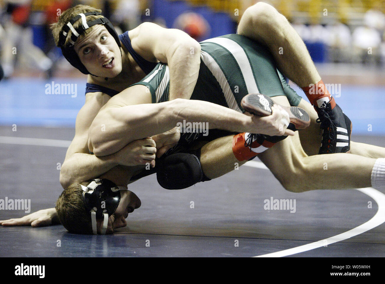 West Virginia Joe Clarke (oben) sieht auf die Uhr prüfen, wie er reitet Cleveland State Anthony Coleman während ihres Gleichen in der 141 lbs Klasse während die Viertelfinale der NCAA Division 1 Wrestling Meisterschaften am Savvis Center in St. Louis am 19. März 2004. (UPI Foto/Rechnung Greenblatt) Stockfoto