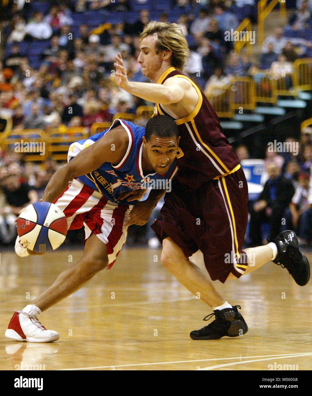 Harlem Globetrotters Chris Sandy (L) versucht, Vergangenheit New York Staatsangehörigen Shaun Faust im ersten Quartal ihr Spiel an das Savvis Center in St. Louis am 7. Januar 2005 zu erhalten. (UPI Foto/Rechnung Greenblatt) Stockfoto