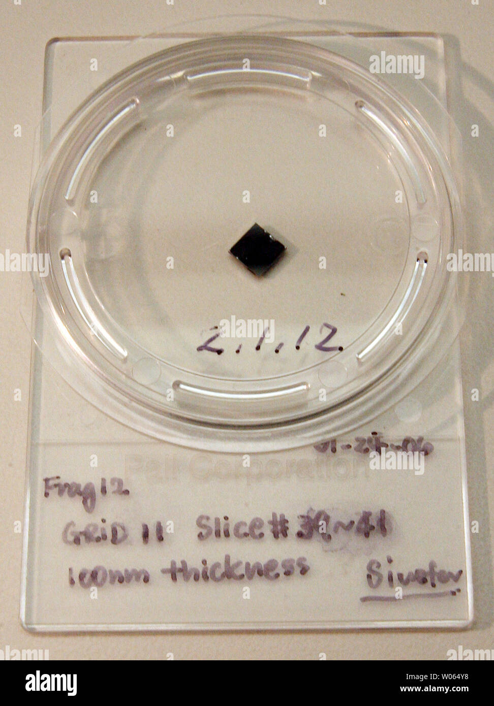 Frank Stadermann, Ph.D., Senior Research Scientist in der Abteilung für Physik an der Washington Universität hat einen Container mit drei Schichten eines kometarer Staubpartikel während der NASA sieben gesammelt erhalten 2,88 Milliarden Kilometer Roundtrip Stardust Mission kometaren und interstellaren Staubteilchen zu sammeln, in der St. Louis am 9. Februar 2006. Stadermann, der auch Berater in der Stardust Mission, ging zum Johnson Space Center der NASA in Houston, Zeuge der Eröffnung am 17. Januar des wiederhergestellten Stardust probe Kanister, 15. Januar in Utah gelandet. Die Probe Kanister statt ein Fach, erfassen Stockfoto