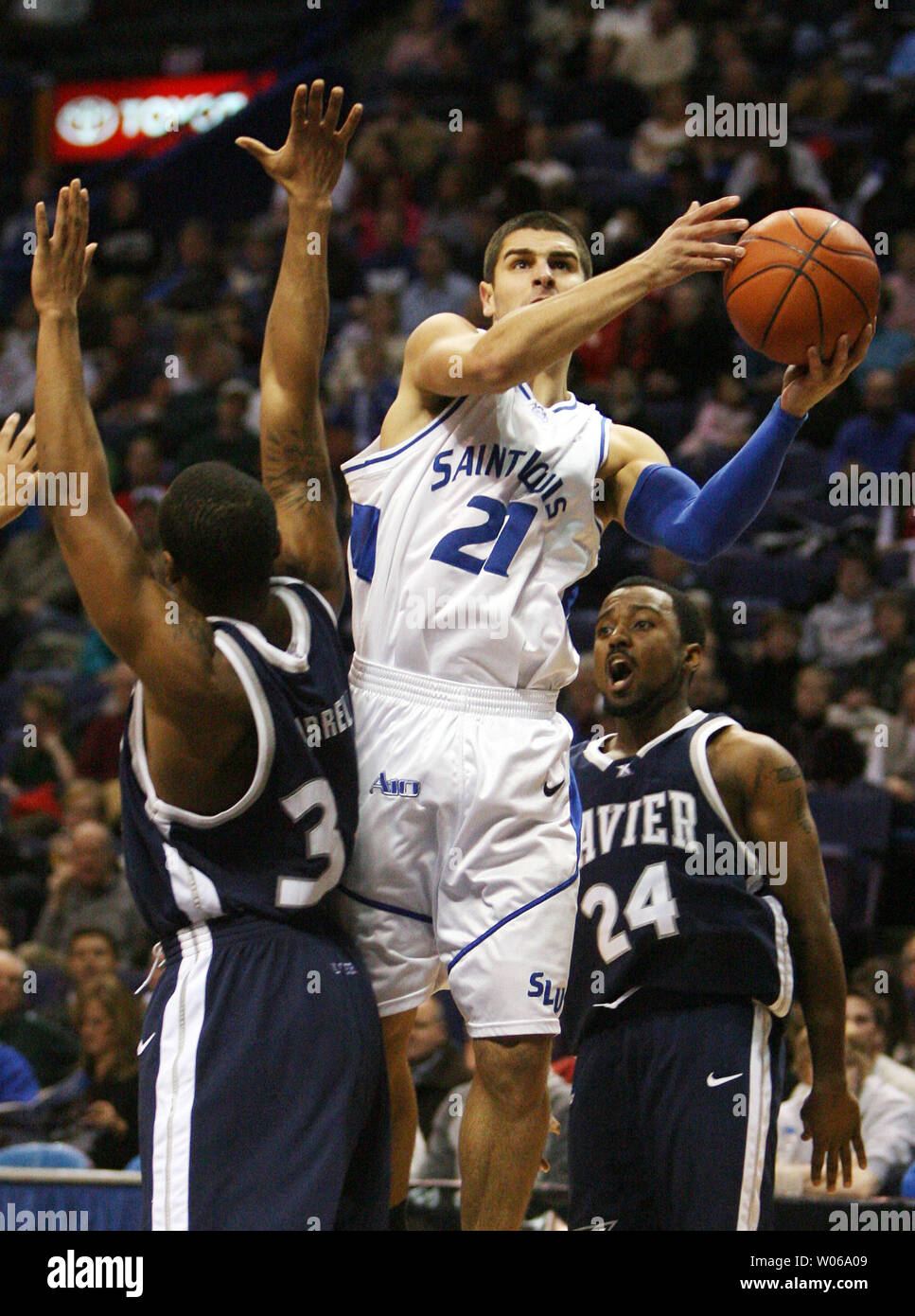 Saint Louis University Billikens Kevin Lisch (21) Schnitte durch die Xavier Musketiere Verteidigung von Stanley Burrell (L) und Drew Lavendel (24) für zwei Punkte in der ersten Hälfte im Scottrade Center in St. Louis am 13. Januar 2007. (UPI Foto/Rechnung Greenblatt) Stockfoto