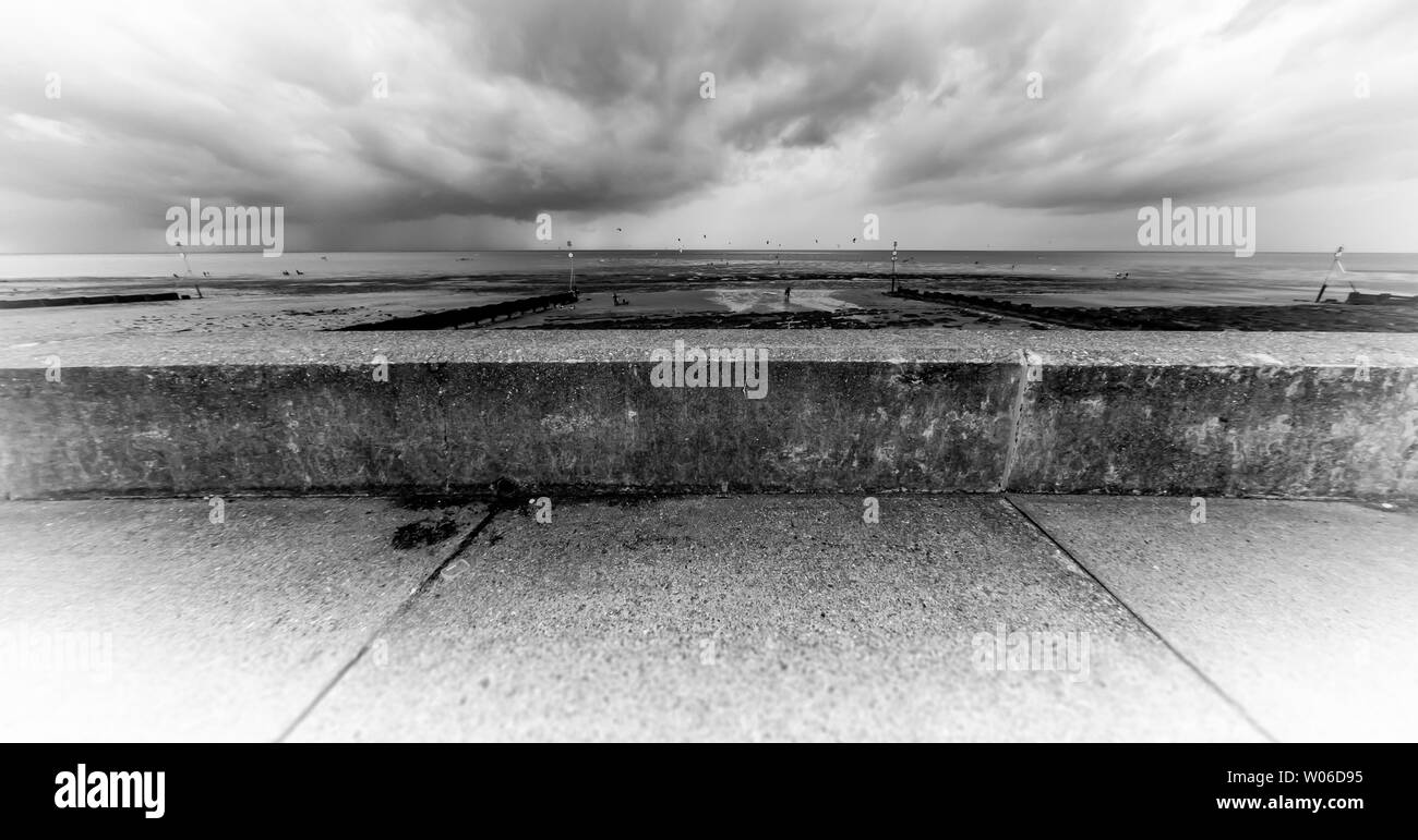 Breite schwarze und weiße Schuß von Hunstanton Beach in Norfolk, Gleitschirme gegen ein Dramatischer Himmel Stockfoto