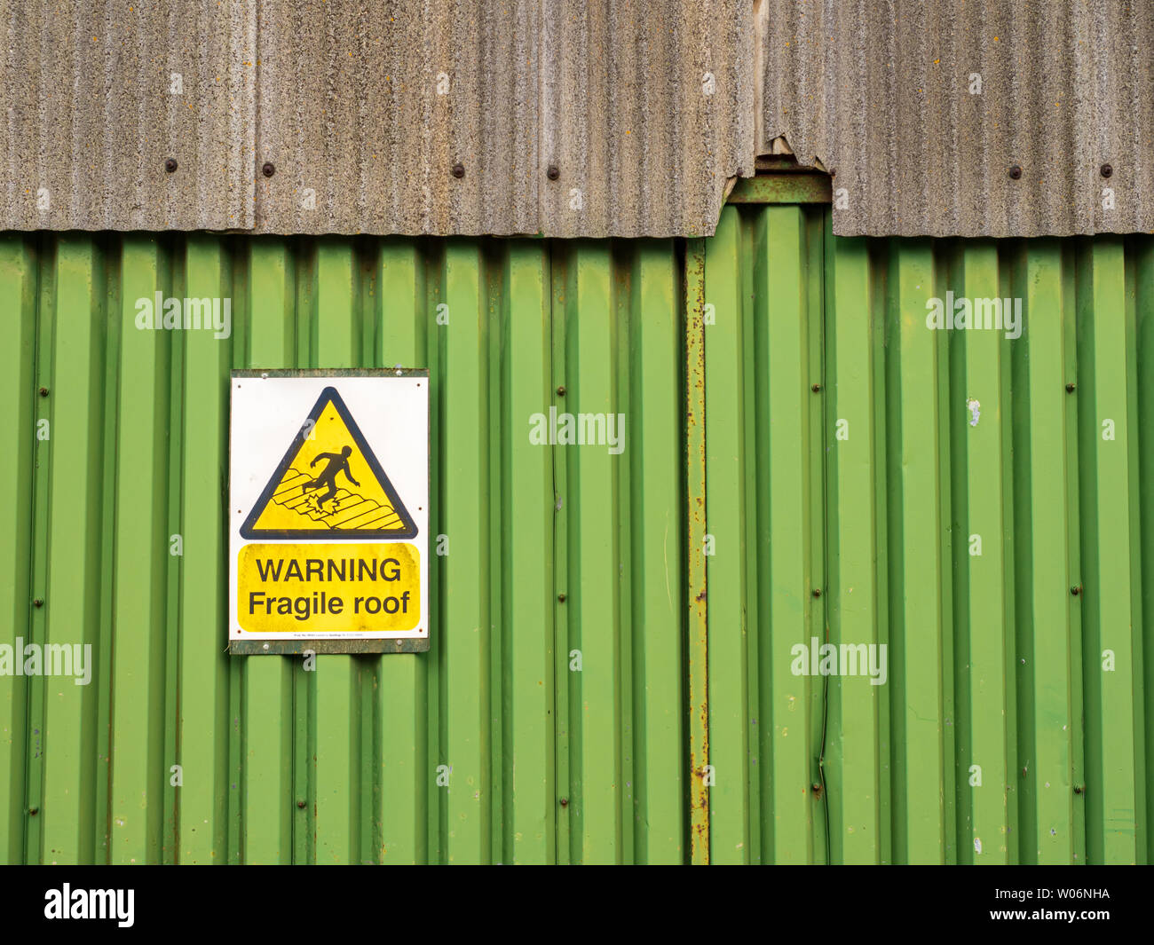 Zerbrechliches Dach Warnschild an der Seite eines Schuppen mit Defekte Wandverkleidung für Gesundheit und Sicherheit Stockfoto