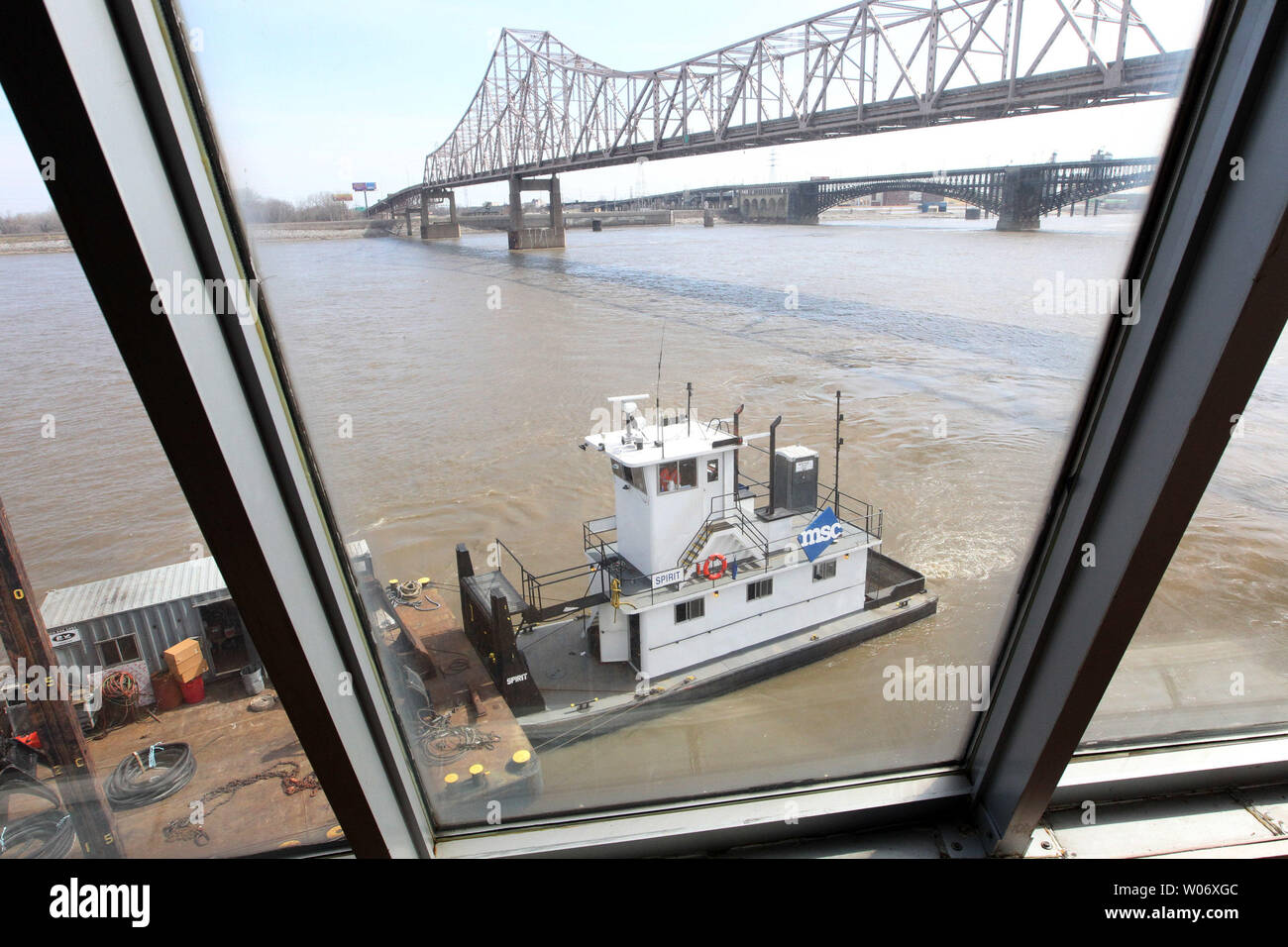 Geist, der TUGBOAT unterstützt Demolierungmannschaften in der Nähe der Dr. Martin Luther King Brücke, wie durch das hintere Fenster des Riverboat Admiral auf der St. Louis Riverfront in St. Louis am März 11, 2011 gesehen. Die Arbeit geht weiter als Besatzungen bis das Boot mit Fackeln vor dem Boot flussaufwärts reisen nach Alton, Illinois, wo es verschrottet wird. Der Admiral war einst als das größte Kreuzfahrtschiff der Welt und der erste Mississippi Riverboat zu voll klimatisiert werden aufgezeichnet. In den 1990er Jahren der Admiral wurde ein Riverboat casino, wie der 'Präsident Casino auf dem Admiral', die ou ging bekannt Stockfoto