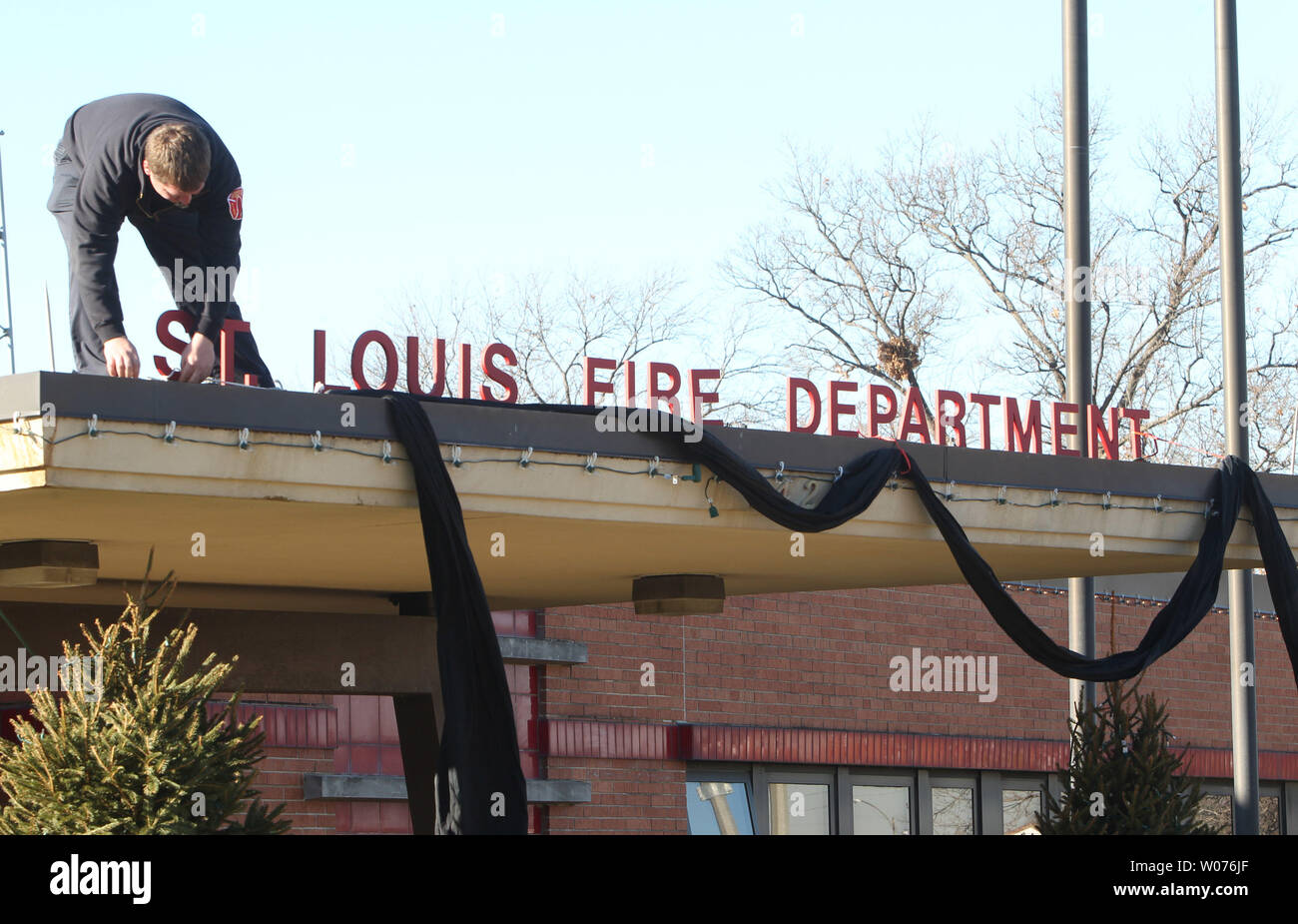 St. Louis Feuerwehrmann Brad Trower arbeitet schwarz Krepp an der Vorderseite der Feuerwehr Hauptquartier zu montieren, nachdem bekanntgegeben wurde, dass Feuerwehrmann Jeffrey Hudson, die in der Linie der Aufgabe gestorben in St. Louis am 12. Dezember 2012. UPI/Rechnung Greenblatt Stockfoto