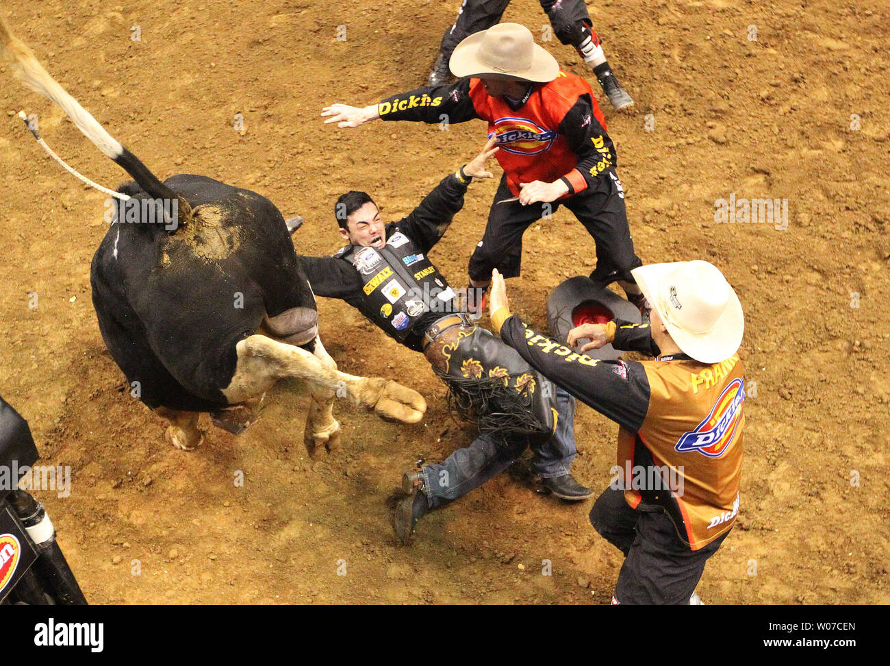 Stier Kämpfer rush im Reiter Marco Eguchi, nachdem sie weg von der RFD-HD der Stier in der dritten Runde der Professional Bull Riders im Scottrade Center in St. Louis am 16. Februar 2014 zu helfen. UPI/Rechnung Greenblatt Stockfoto