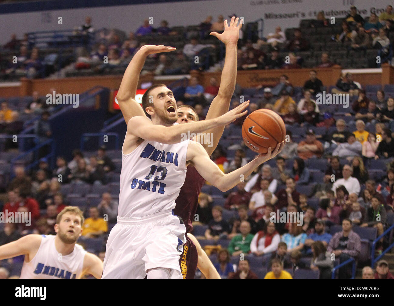 Indiana State Platanen Jake Odum erhält hinter Loyola Ramblers Nick Osborne für ein layup in der ersten Hälfte während der Missouri Valley Conference Turnier im Scottrade Center in St. Louis am 7. März 2014. UPI/Rechnung Greenblatt Stockfoto