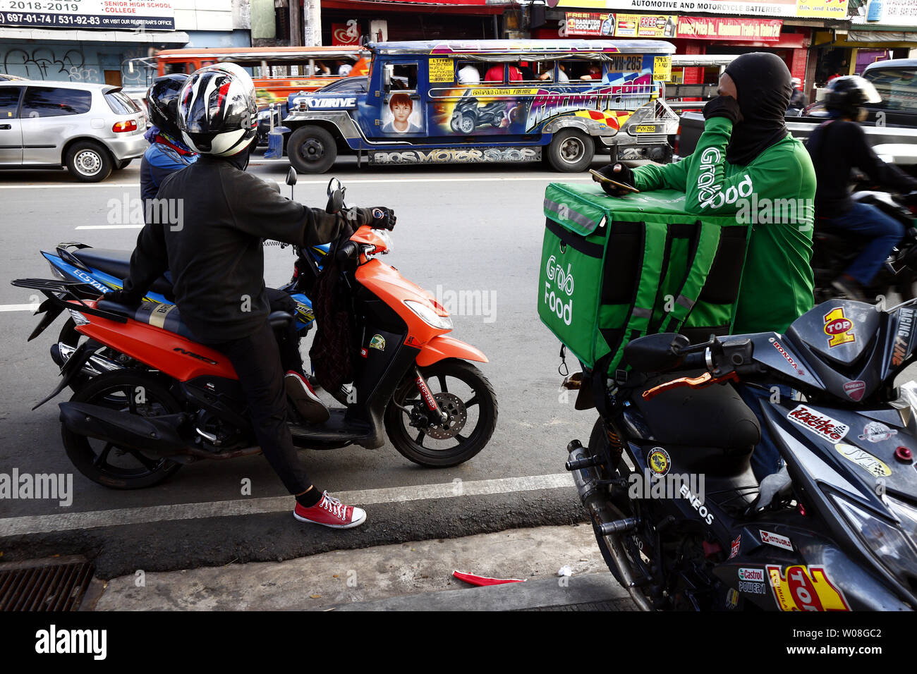 ANTIPOLO CITY, Philippinen - 24. JUNI 2019: Motorradfahrer und motorisierte boten Rest an der Seite der Straße. Stockfoto