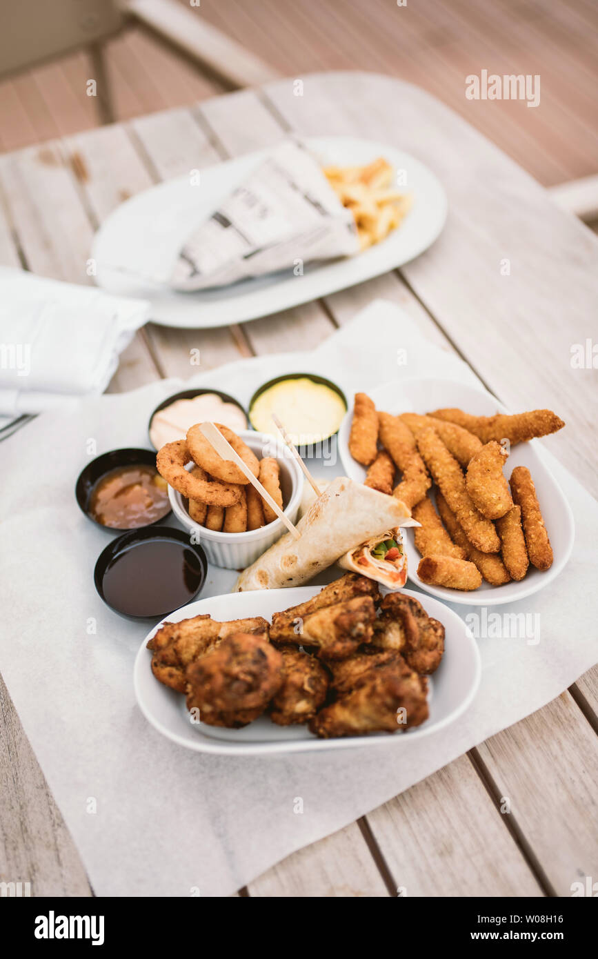Verschiedene Arten von Frittierten Snacks: Huhn, Käse, Zwiebel und Tortillas auf hölzernen Tisch Stockfoto