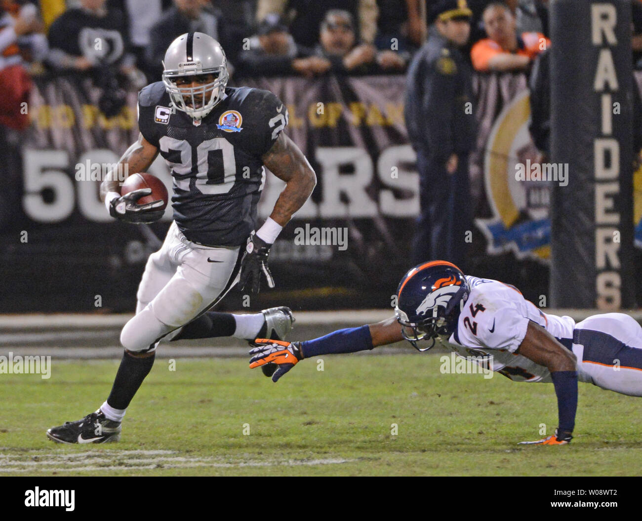 Oakland Raiders RB Darren McFadden (20) fegt über die ausgestreckte Hand der Denver Broncos Champ Bailey (24) für 36 Yards im dritten Quartal an O. co Coliseum in Oakland, Kalifornien am 6. Dezember 2012. Die Broncos besiegt die Räuber 26-13. UPI/Terry Schmitt Stockfoto