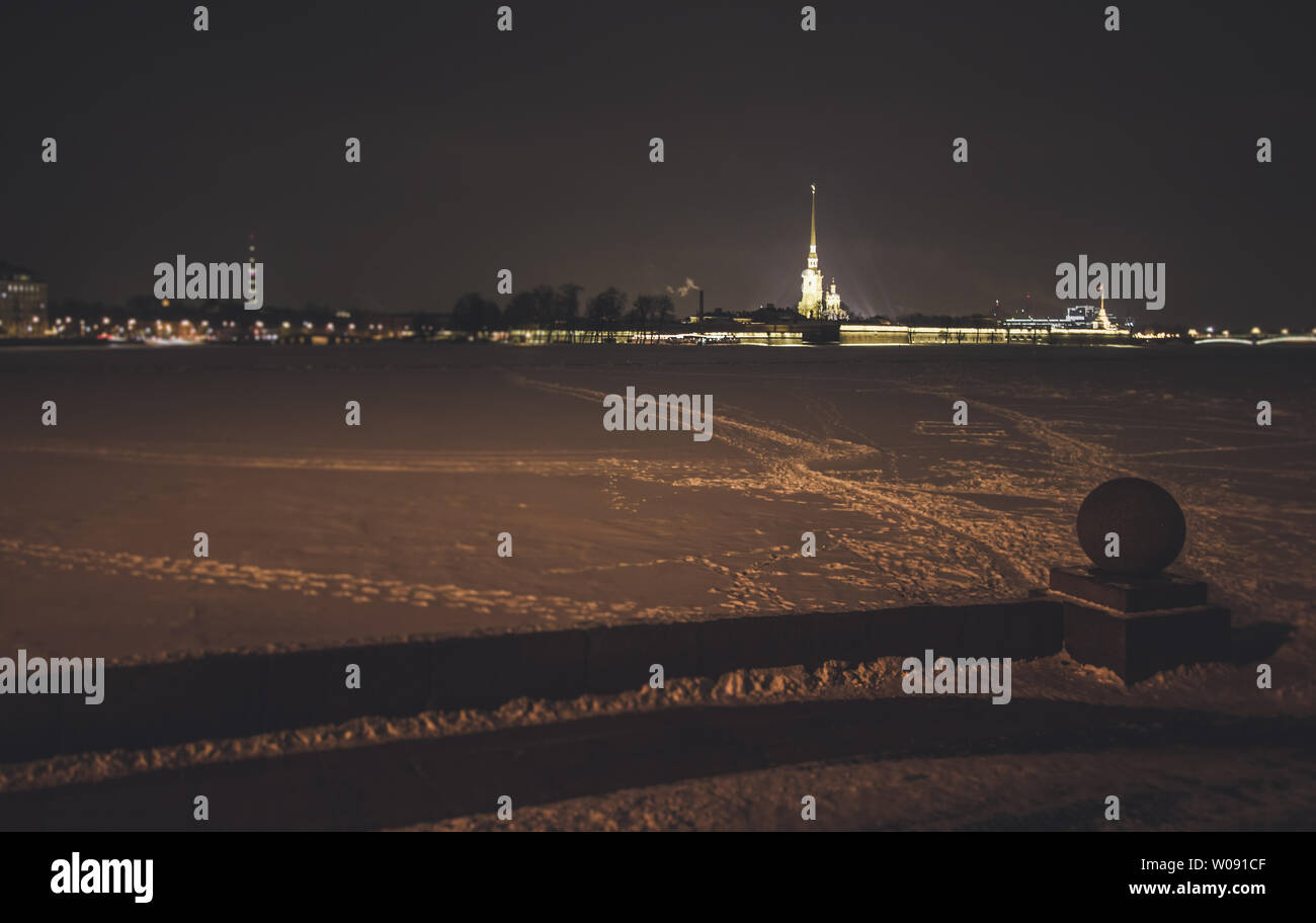 Blick auf den zugefrorenen Fluss Newa und der Peter und Paul Festung im Winter in den Abend mit Schnee Stockfoto