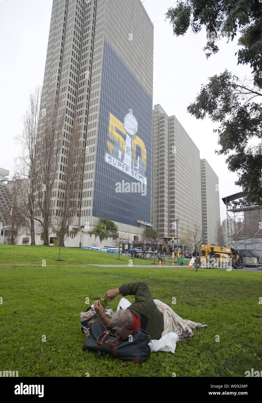 Ein obdachloser Mann schläft Raue im Regen an einem Super Bowl 50 Fan Area entlang dem Embarcadero in San Francisco, am 29. Januar 2016. Die Stadt hat versucht, die Obdachlosen aus, die durch die Fußball-Fans in der Stadt für das Spiel, die besucht werden sollen, zu bewegen. Foto von Terry Schmitt/UPI Stockfoto